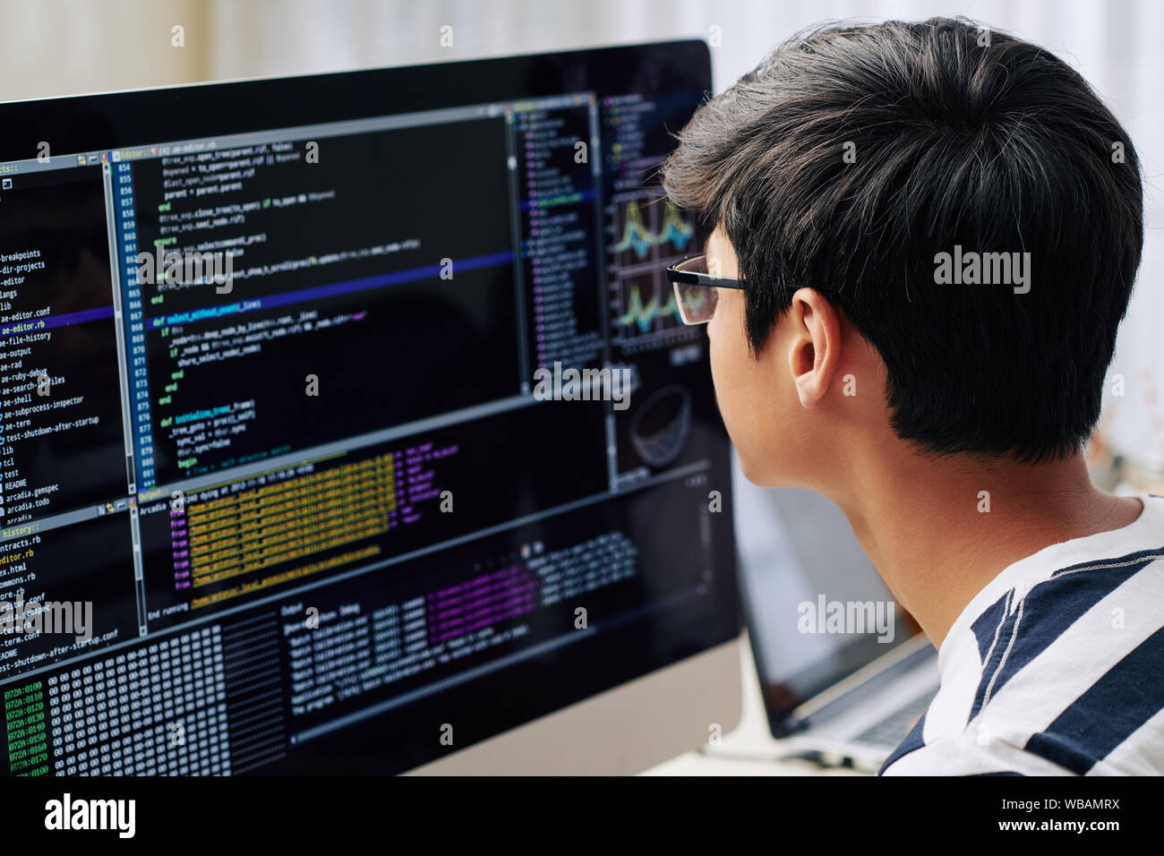 Smart Teenage Boy In Glasses Checking Programming Code On Computer