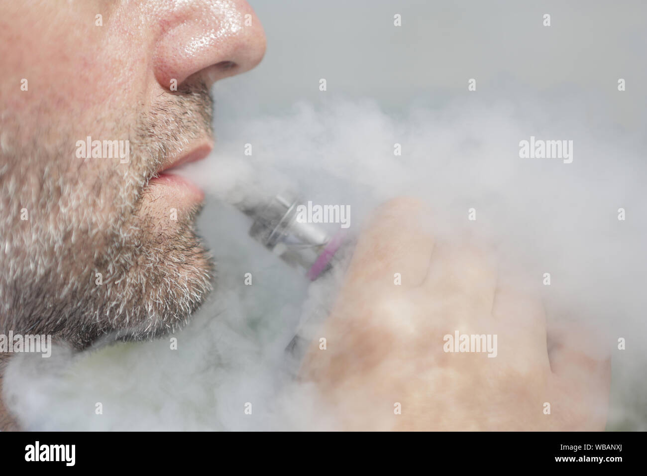 ILLUSTRATION - 24 August 2019, Berlin: A man smokes an e-cigarette (posed  photo). Photo: Lisa Ducret/dpa Stock Photo - Alamy