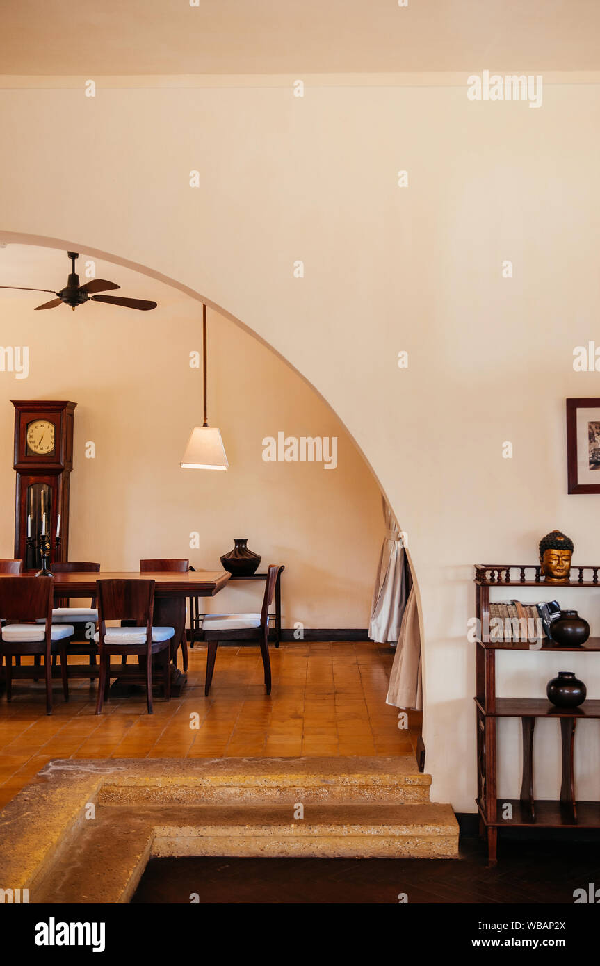 FEB 25, 2014 Dalat, Vietnam - Vintage ceramic tile floor dinner room with hard wood table, chair, white curtain, classic pedant lamps and Asian style Stock Photo