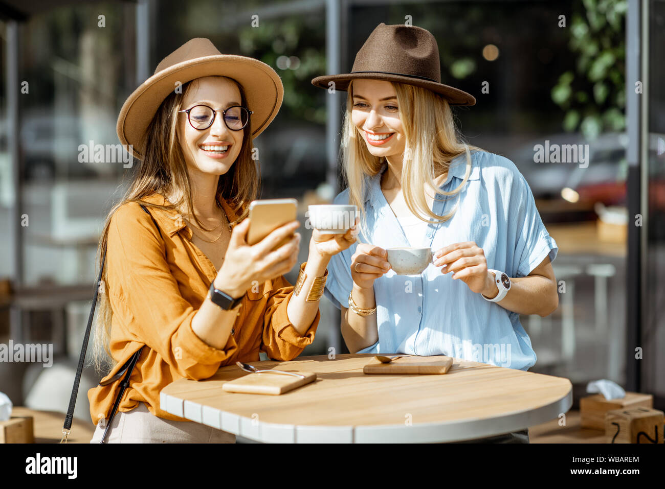 Two female best friends spending time together on the cafe terrace ...