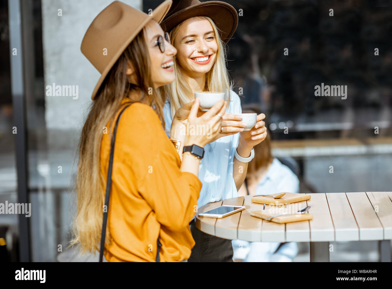 Two female best friends spending time together on the cafe terrace ...