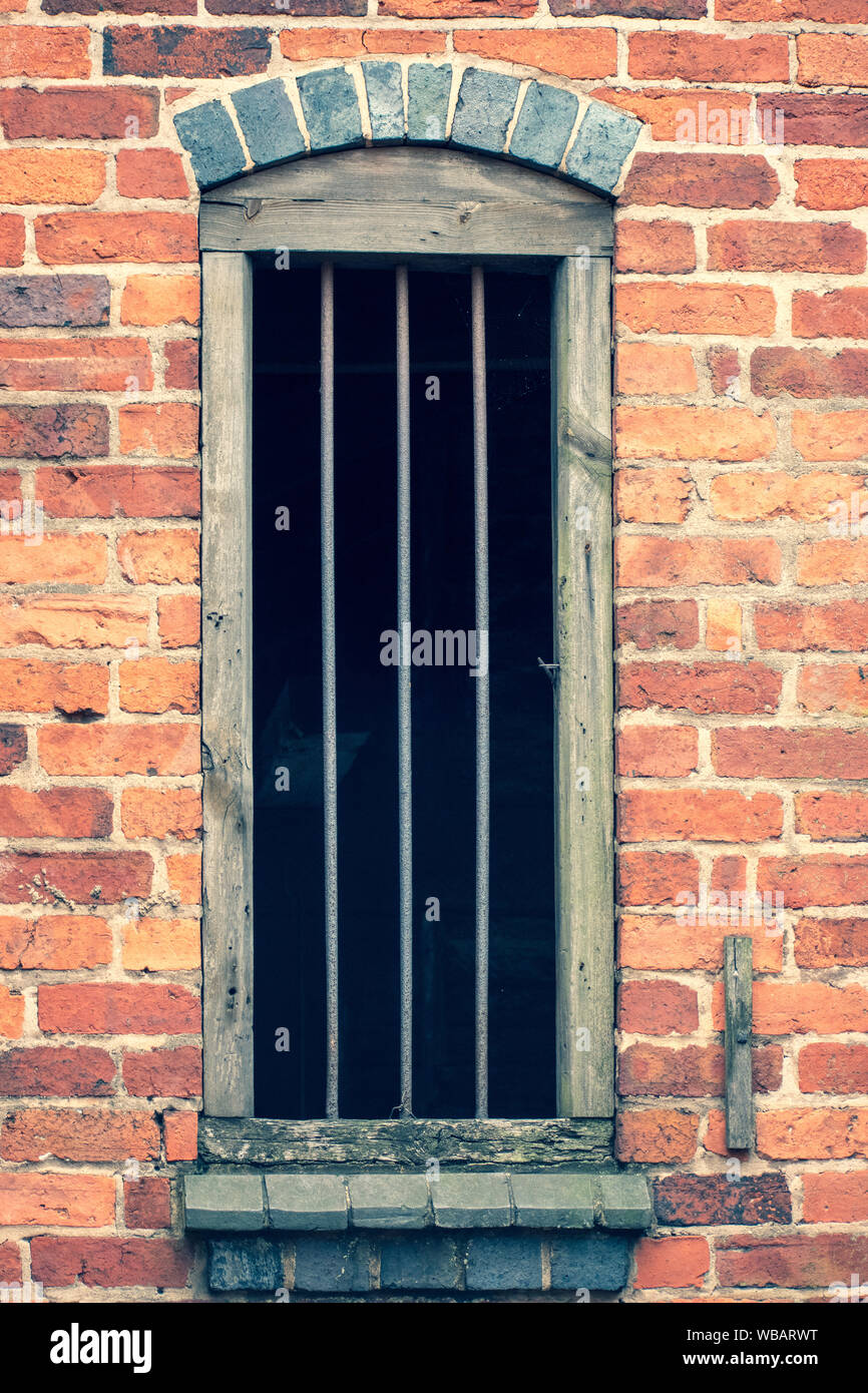 Old fashioned window in storage warehouse, with bars Stock Photo