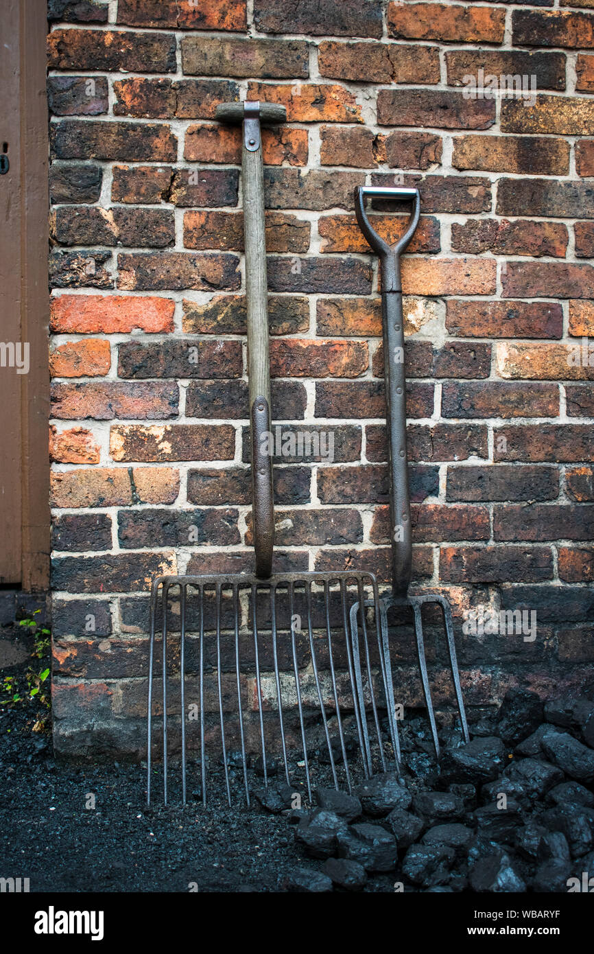 Old forks for moving coal, outside a colliers house. Stock Photo