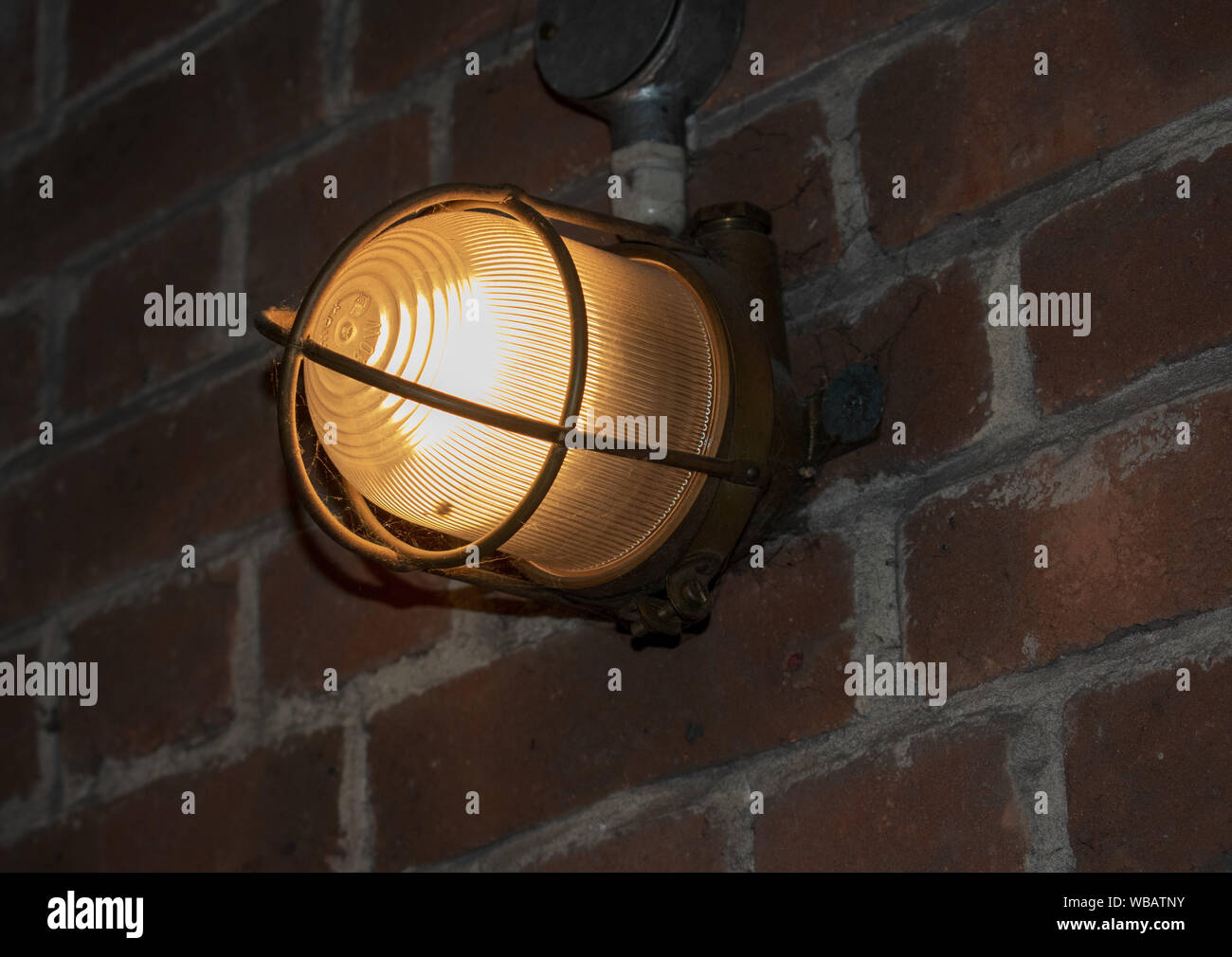 Industrial vintage bunker light on old brick wall Stock Photo
