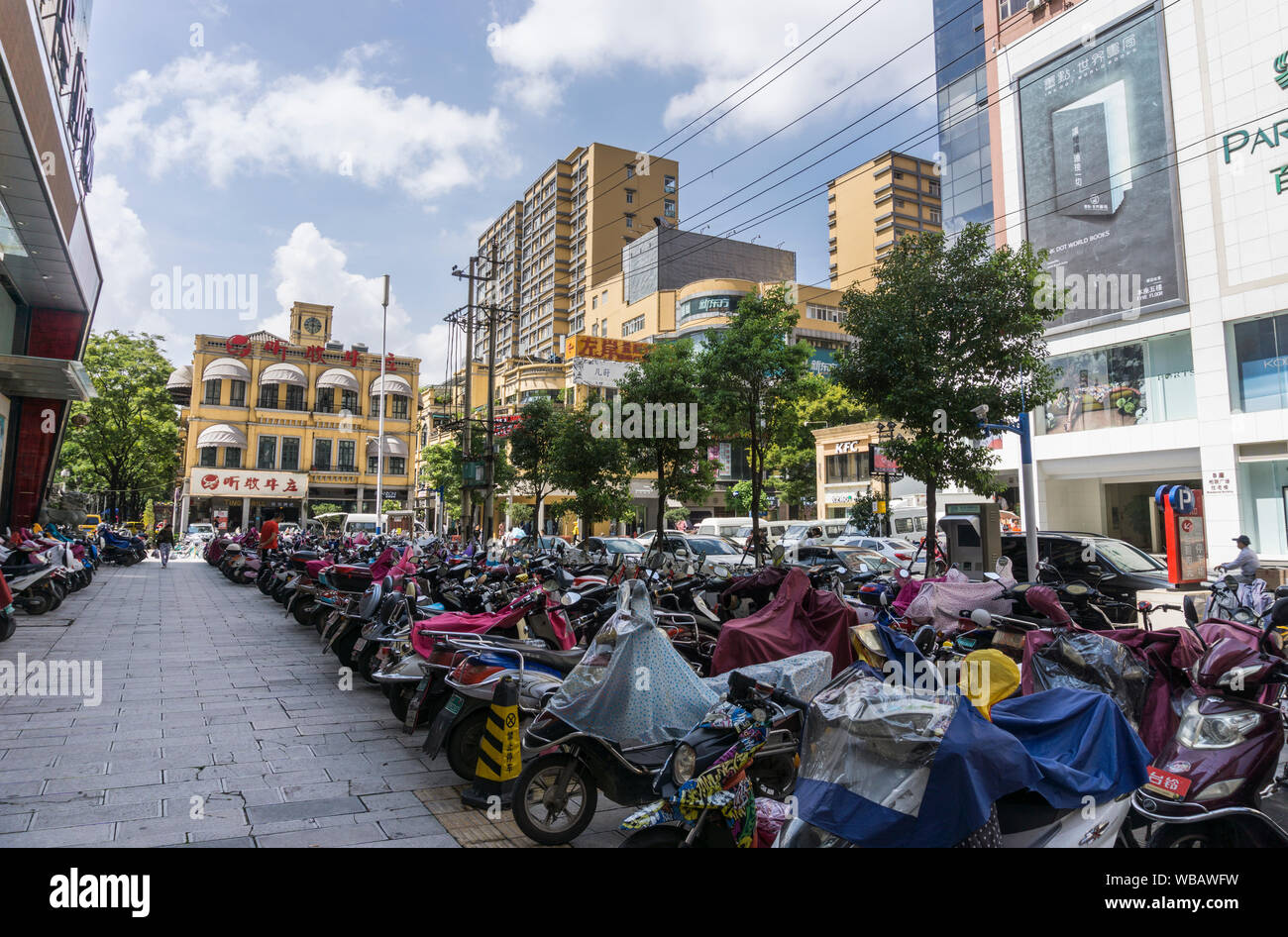 Motor bikes parked up in a city centre street in Kunming, Yunnan ...