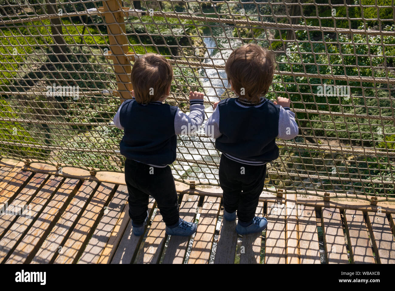 Children facing the suspension bridge Stock Photo Alamy