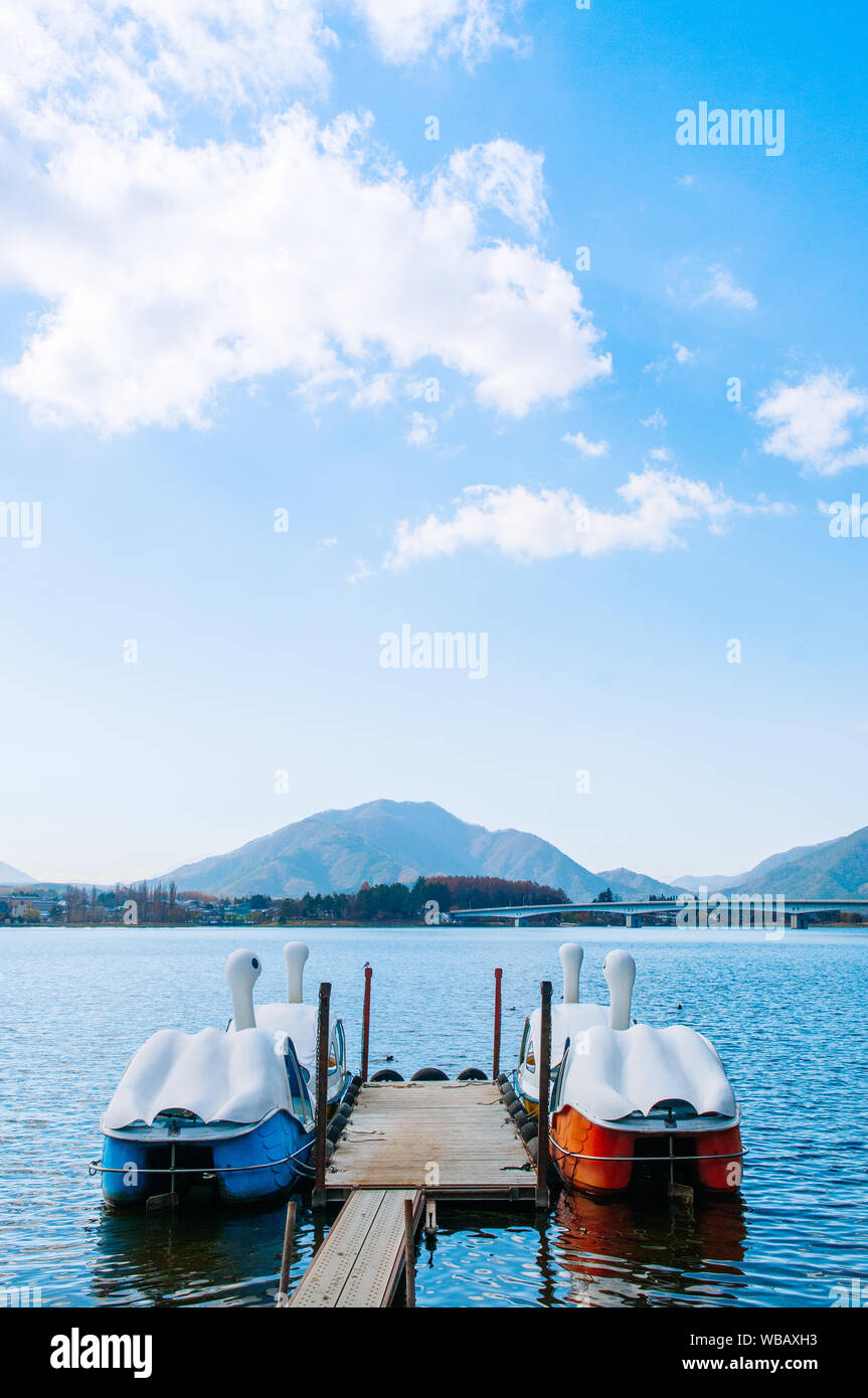 Beautiful Lake Kawaguchiko in winter with swan water bike boats at wooden pier and Ohashi bridge. Yamanashi - Japan Stock Photo