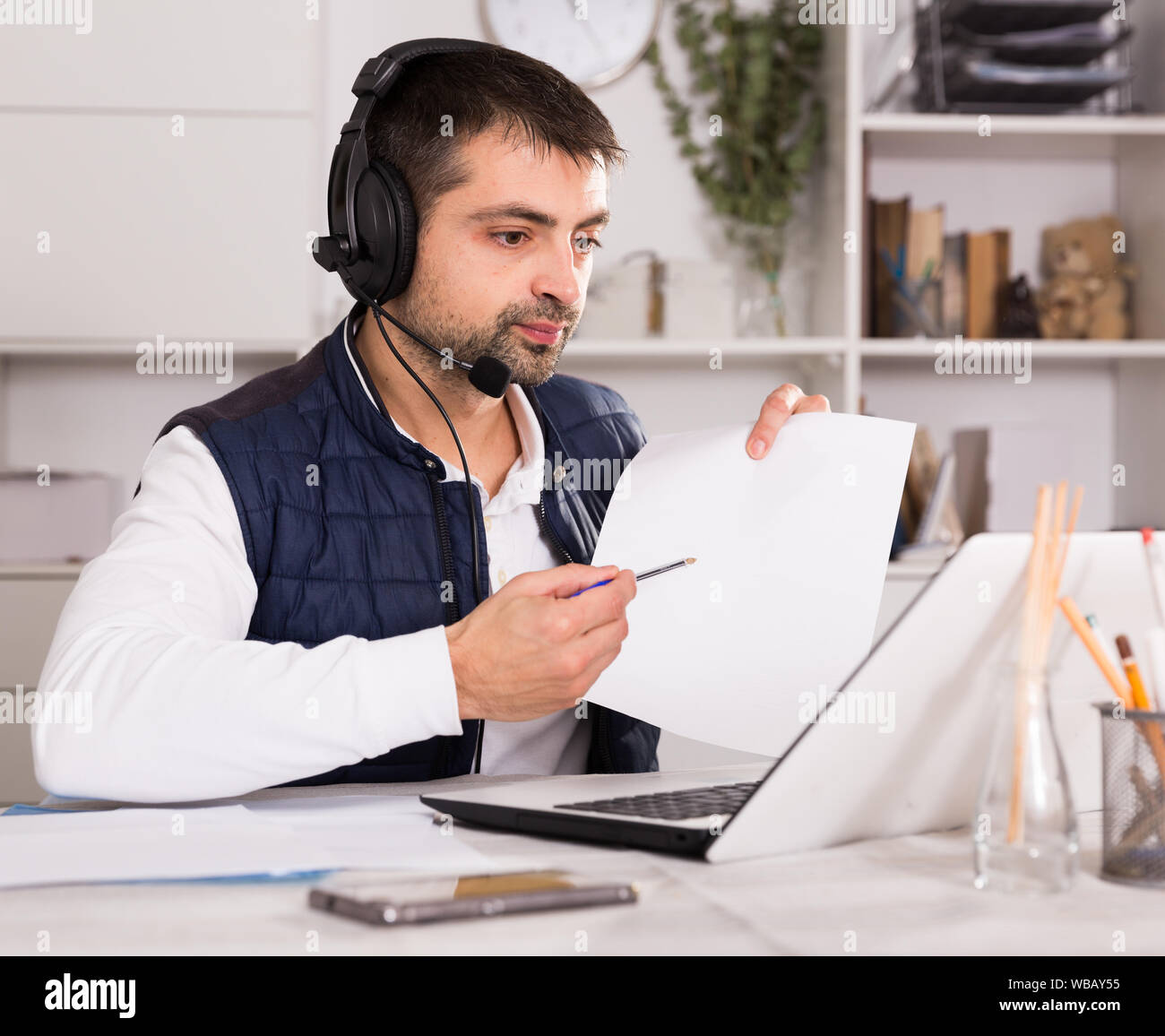 Call center man operator with headset talking with client in agency ...