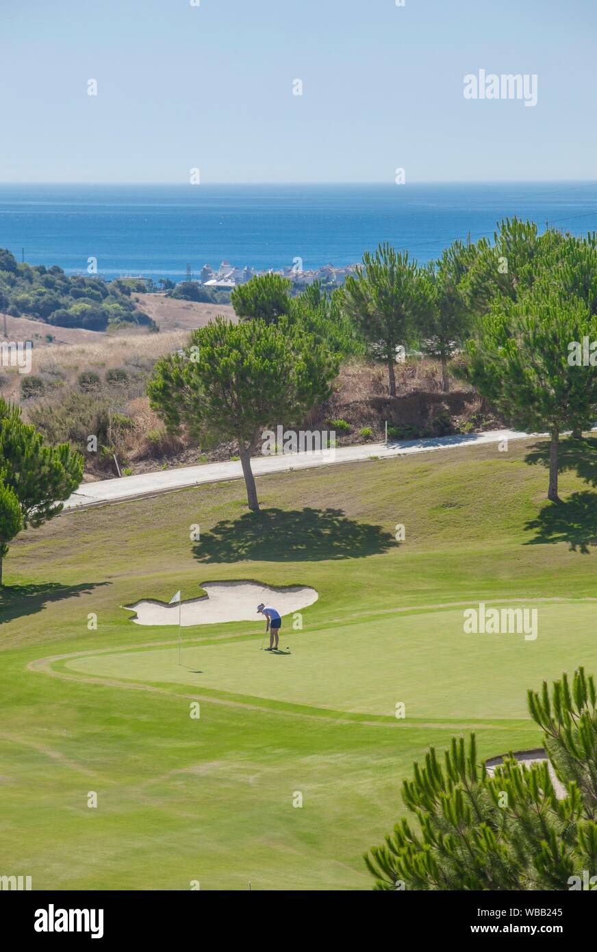 Young female golf player on course playing close to spanish Costa del Sol resort, Estepona, Malaga, Spain. Stock Photo