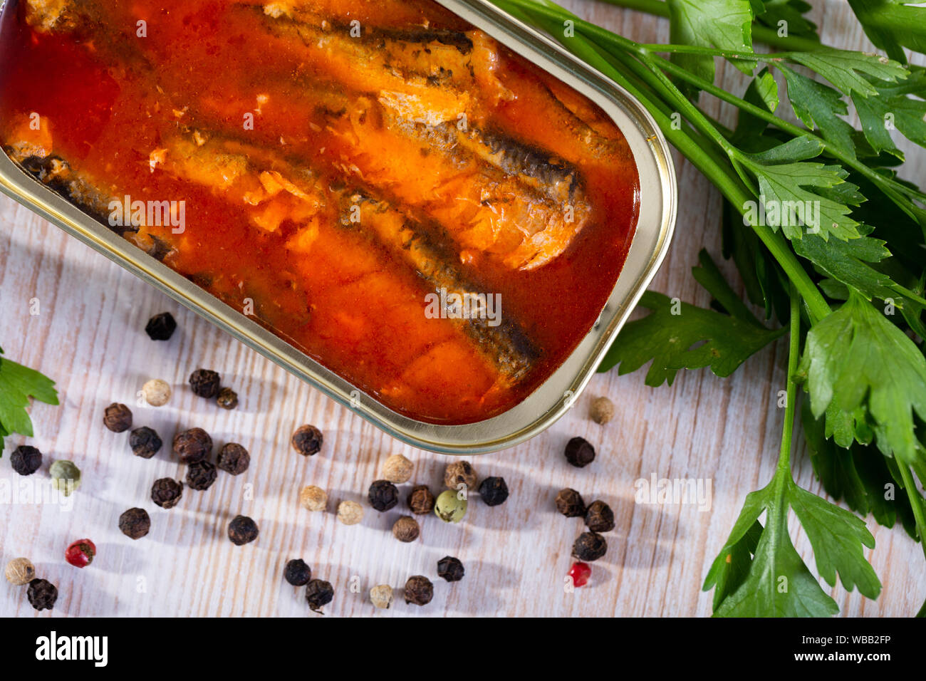 Picture of  tasty sardines in tomato sauce on background with greens and lemon Stock Photo
