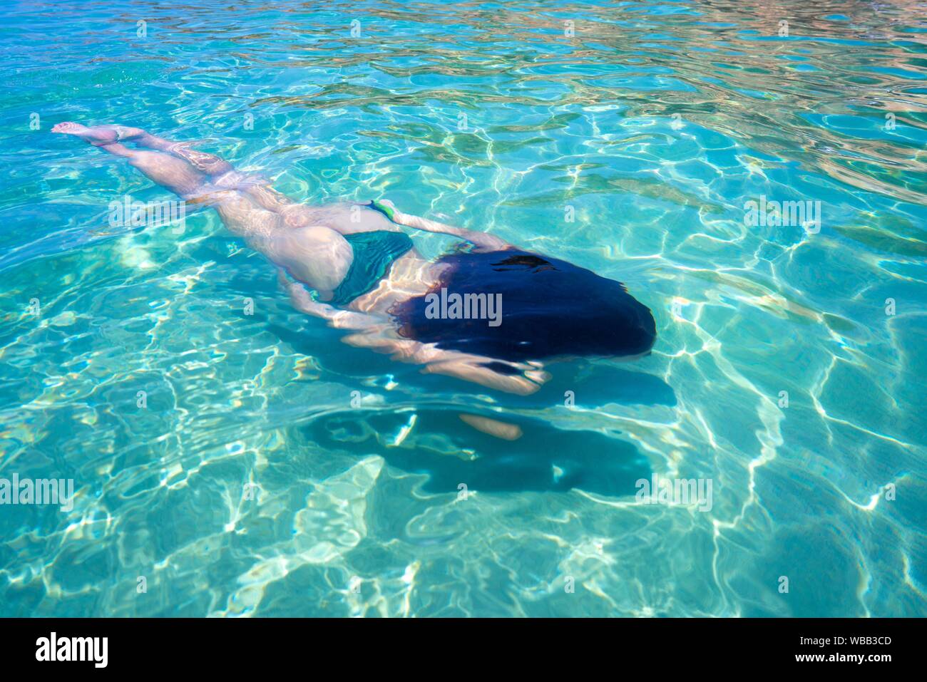 Ibiza bikini girl swimming clear water beach of Balearic Islands. Stock Photo