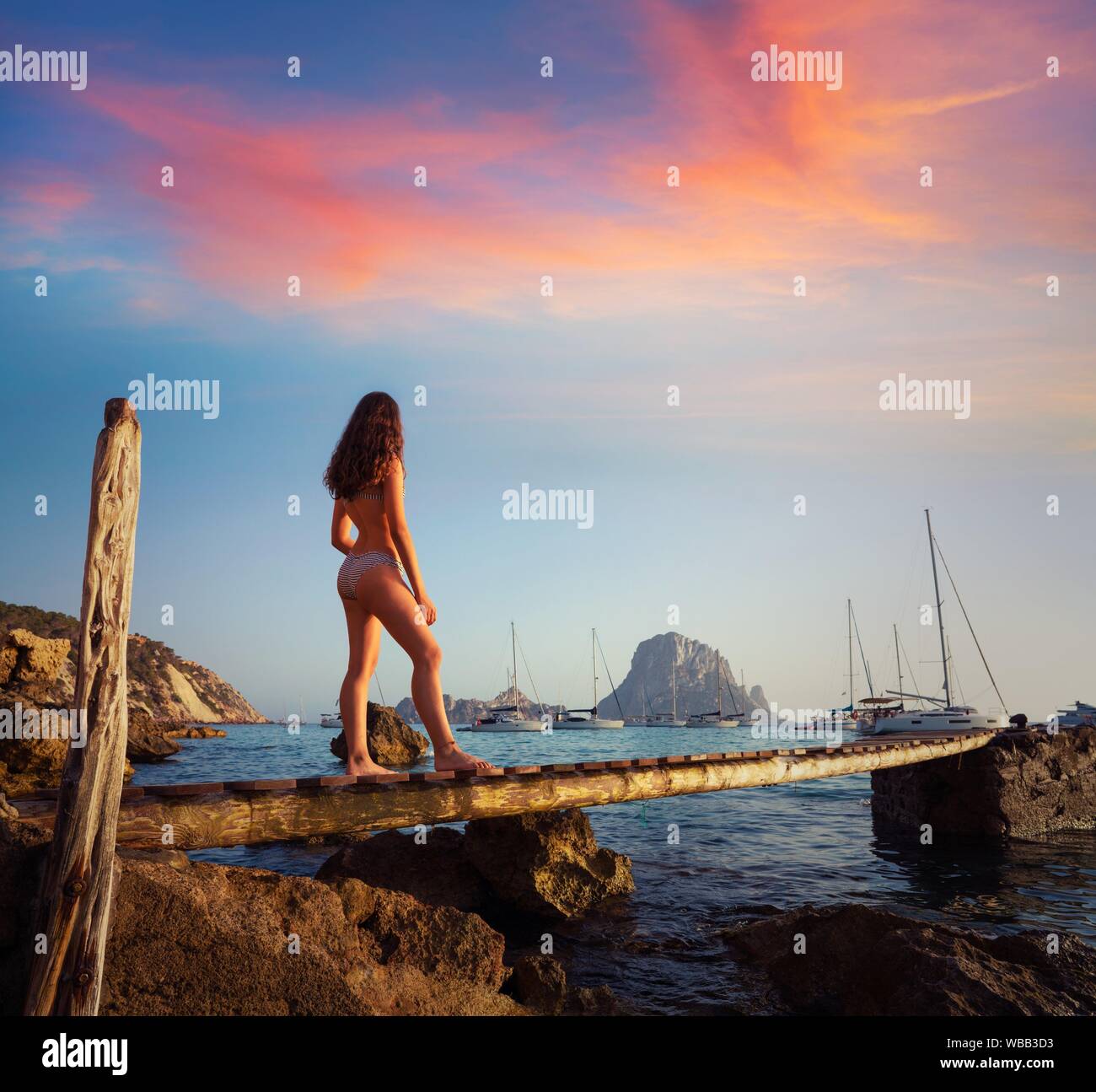 Ibiza cala d Hort girl on pier sunset Es Vedra islet Balearic Islands. Stock Photo