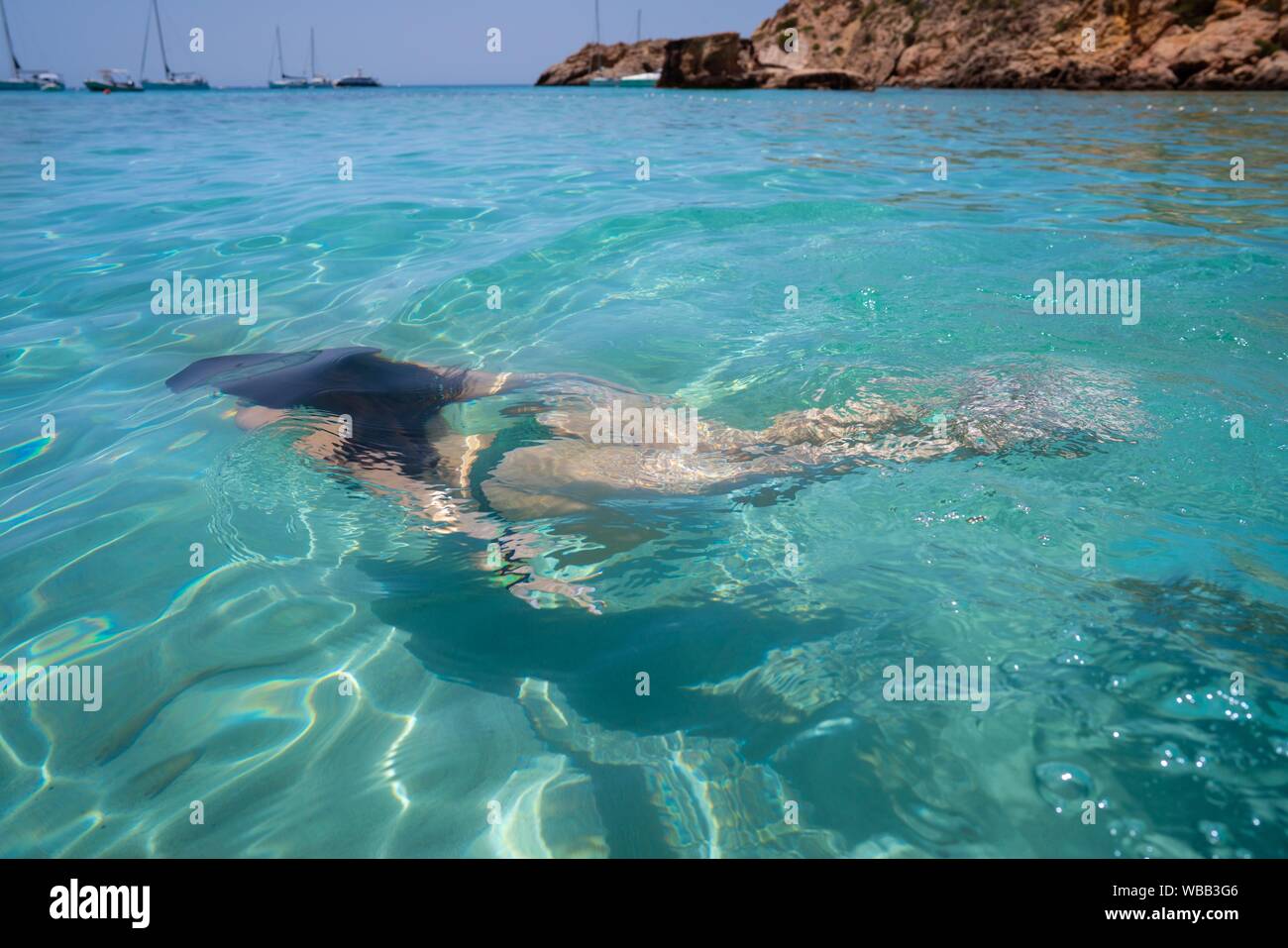 Ibiza bikini girl swimming clear water beach of Balearic Islands. Stock Photo