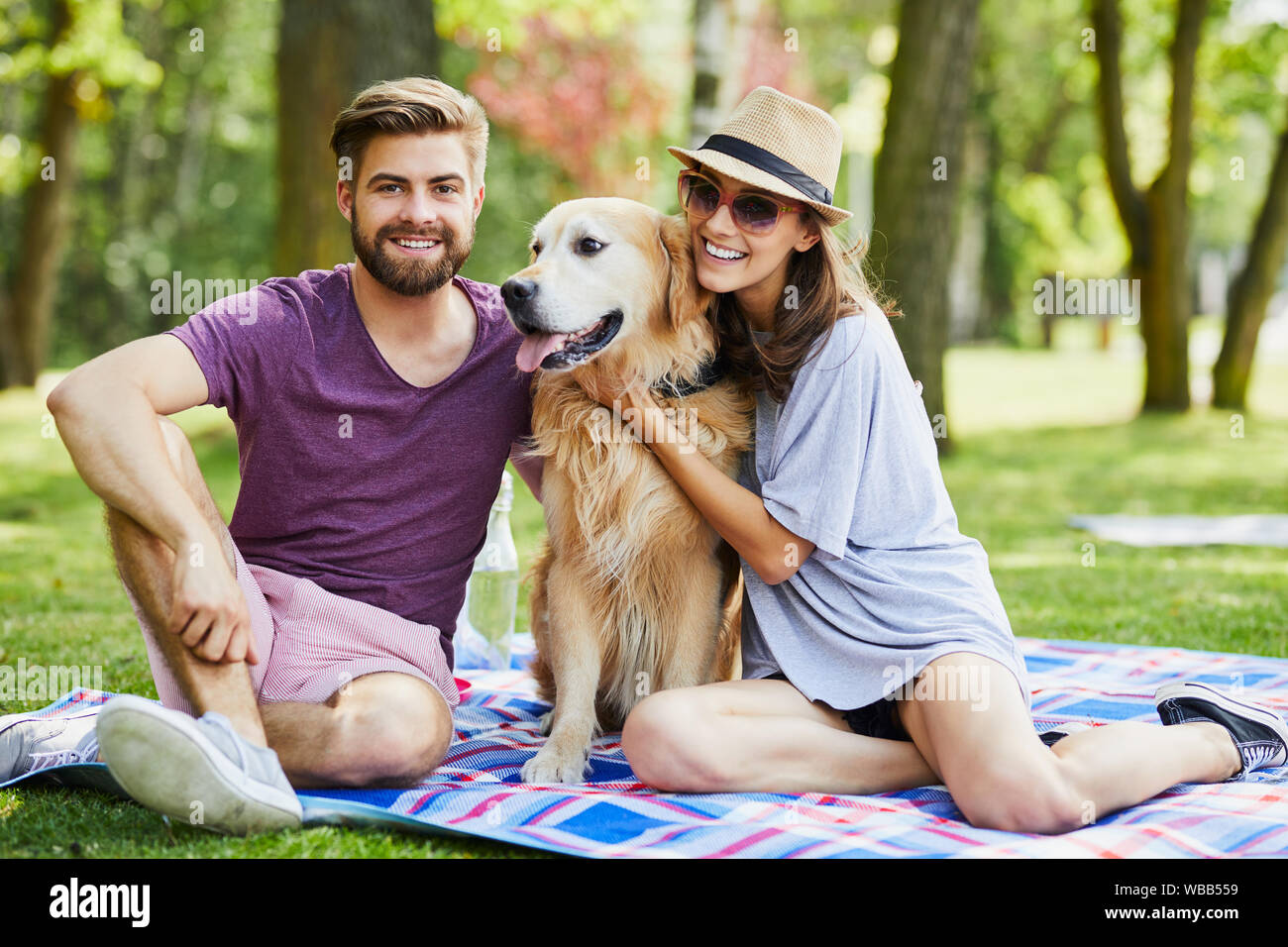 Young couple on a picnic with their dog in the summer Stock Photo - Alamy