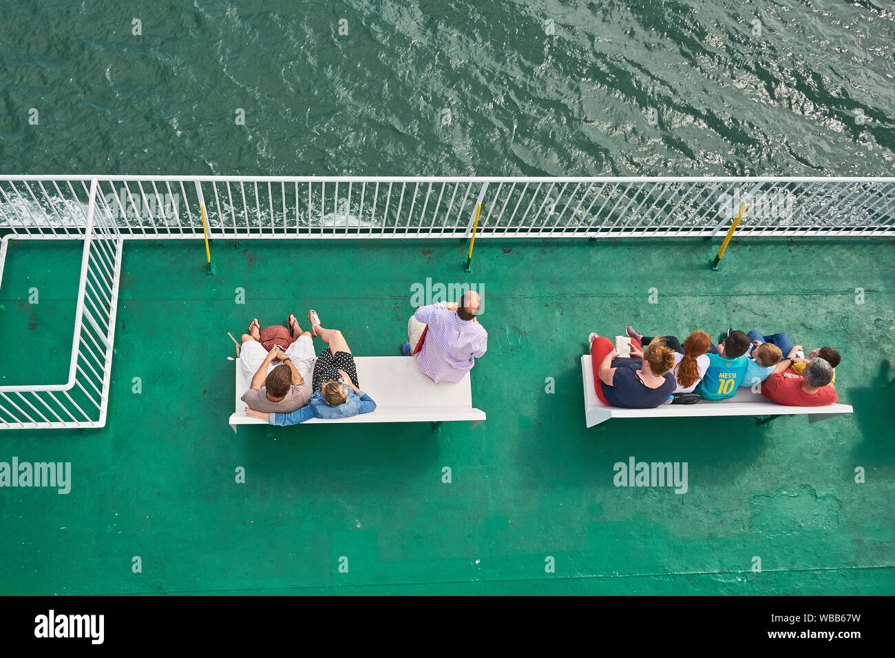Passengers sat on an outside deck whilst on board a passenger ferry Stock Photo