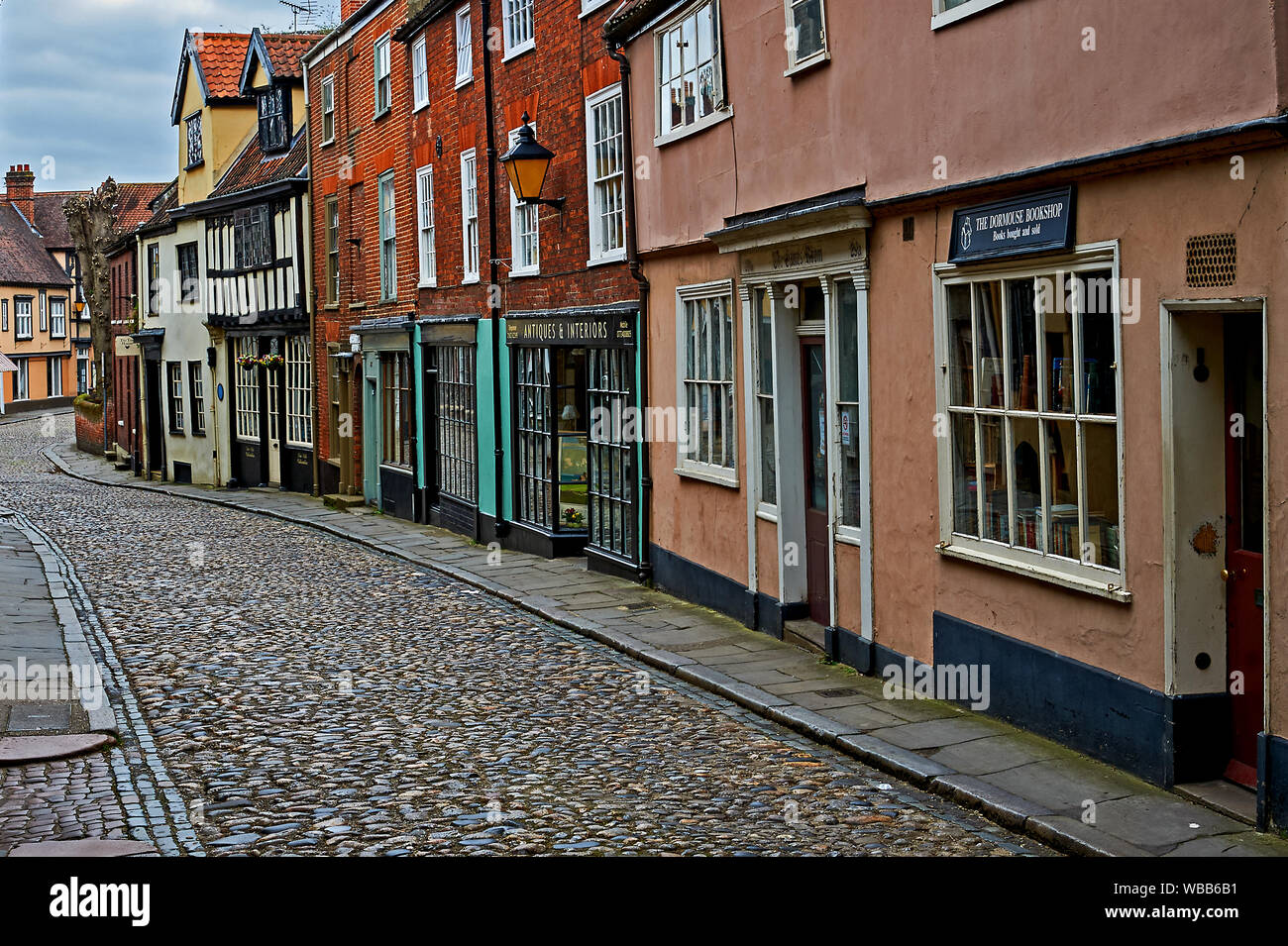 Historic medieval buildings line a cobbled street in the Tombland area of Norwich. Stock Photo