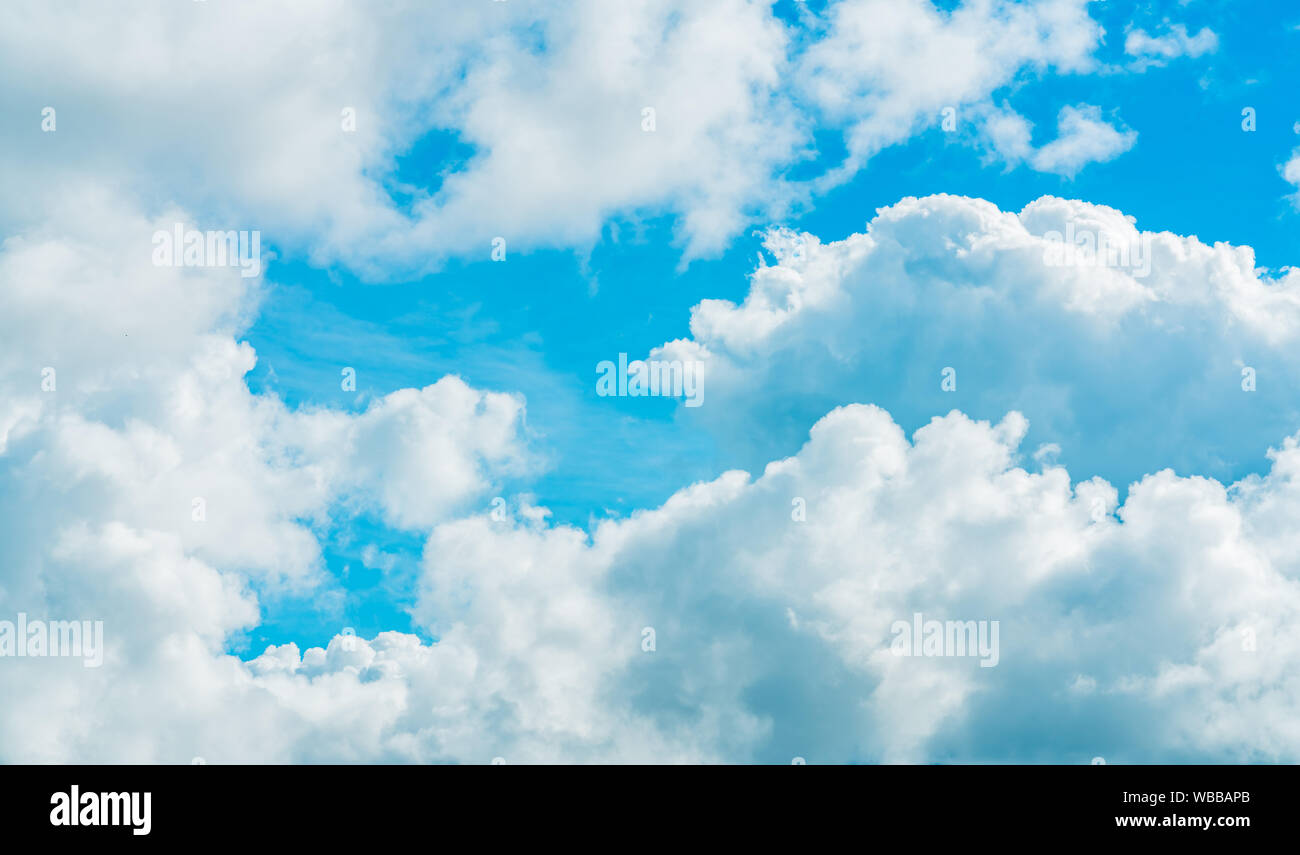 Beautiful blue sky and white cumulus clouds abstract background. Cloudscape background. Blue sky and fluffy white clouds on sunny day. Nature weather. Stock Photo