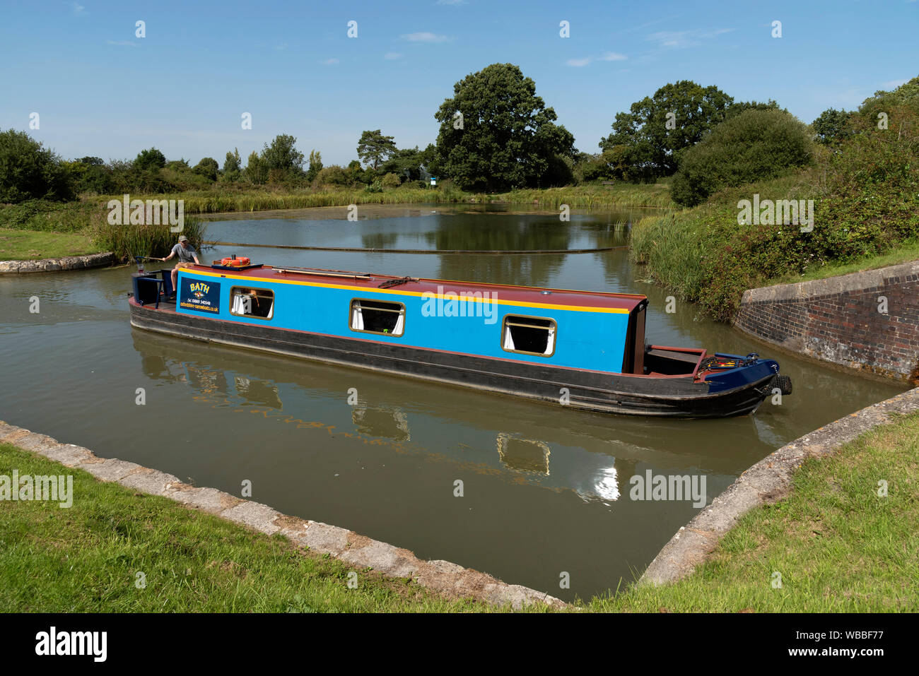 Devizes, Wiltshire, England, UK. August 2019. Narrowboat entering a lock on the Caen Hill flight of locks on the Kennet and Avon Canal. Stock Photo