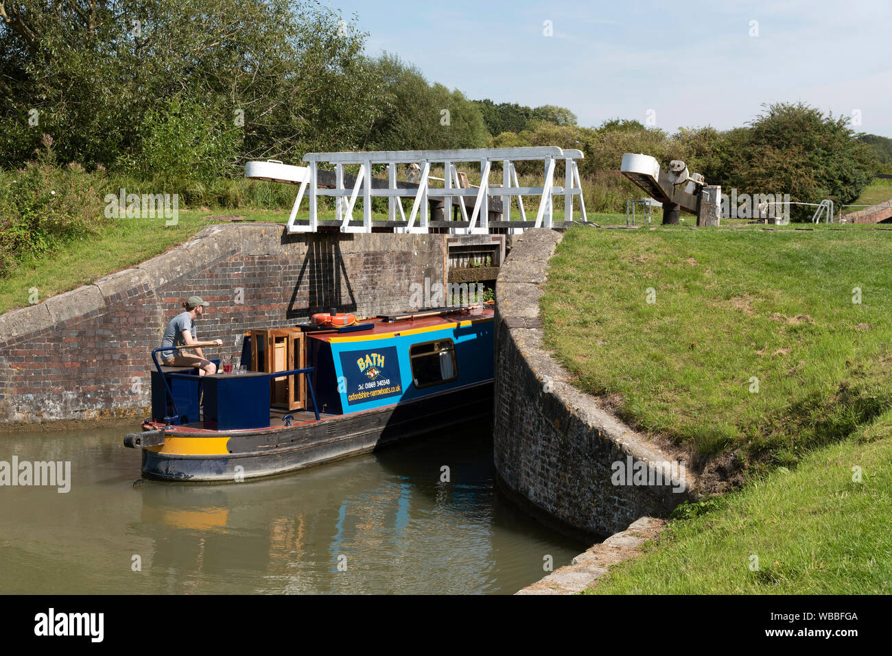 Devizes, Wiltshire, England, UK. August 2019. Narrowboat entering a lock on the Caen Hill flight of locks on the Kennet and Avon Canal. Stock Photo