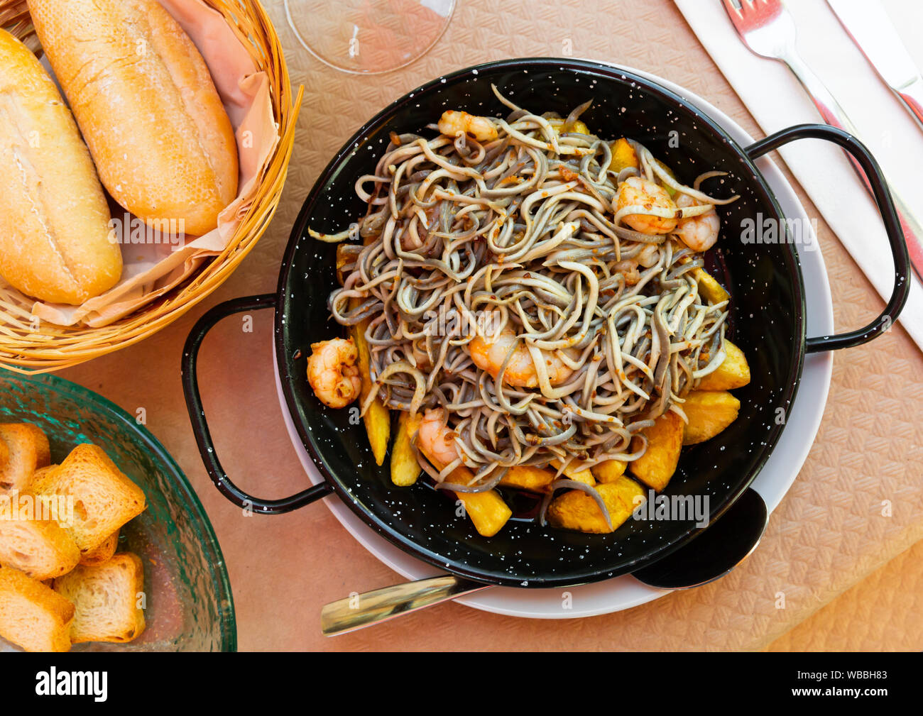 Plate of tasty fried baby eels and prawns with potatoes, nobody Stock