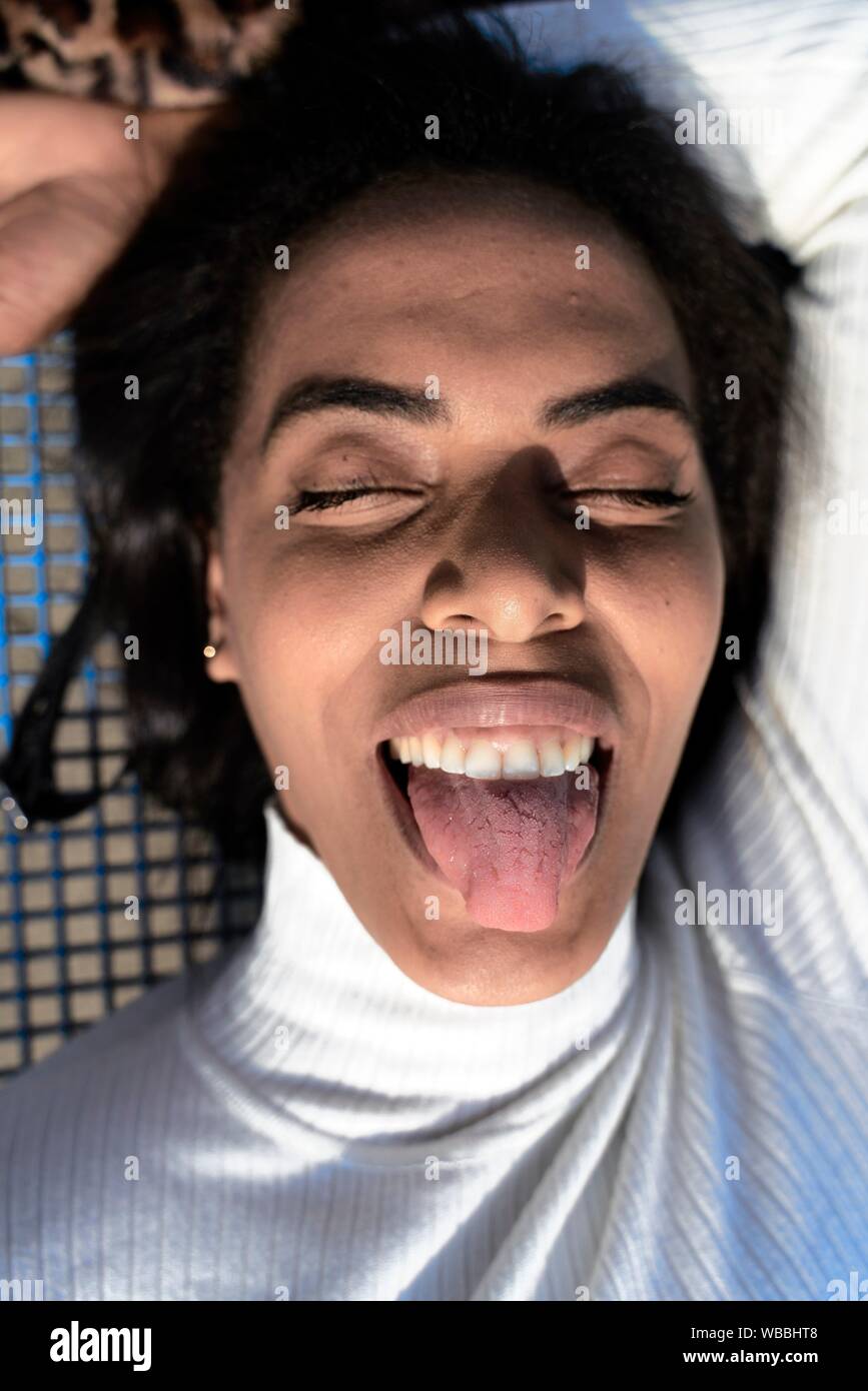 Sticking tongue out woman What does