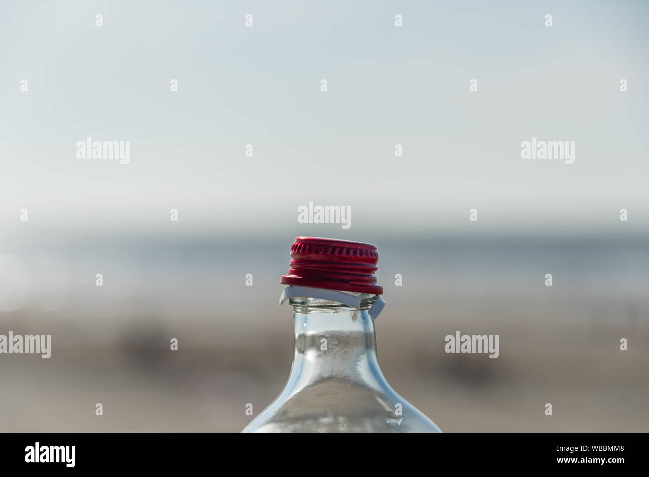 Opened bottle red closure against blury background Stock Photo