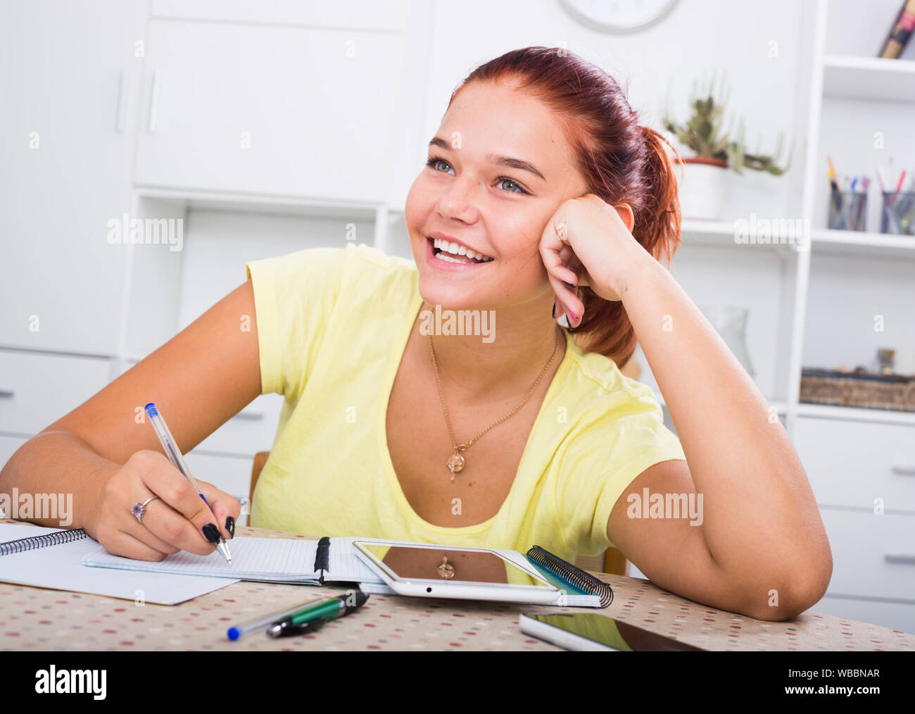 positive teenager girl taking notes while studying at home Stock Photo Alamy