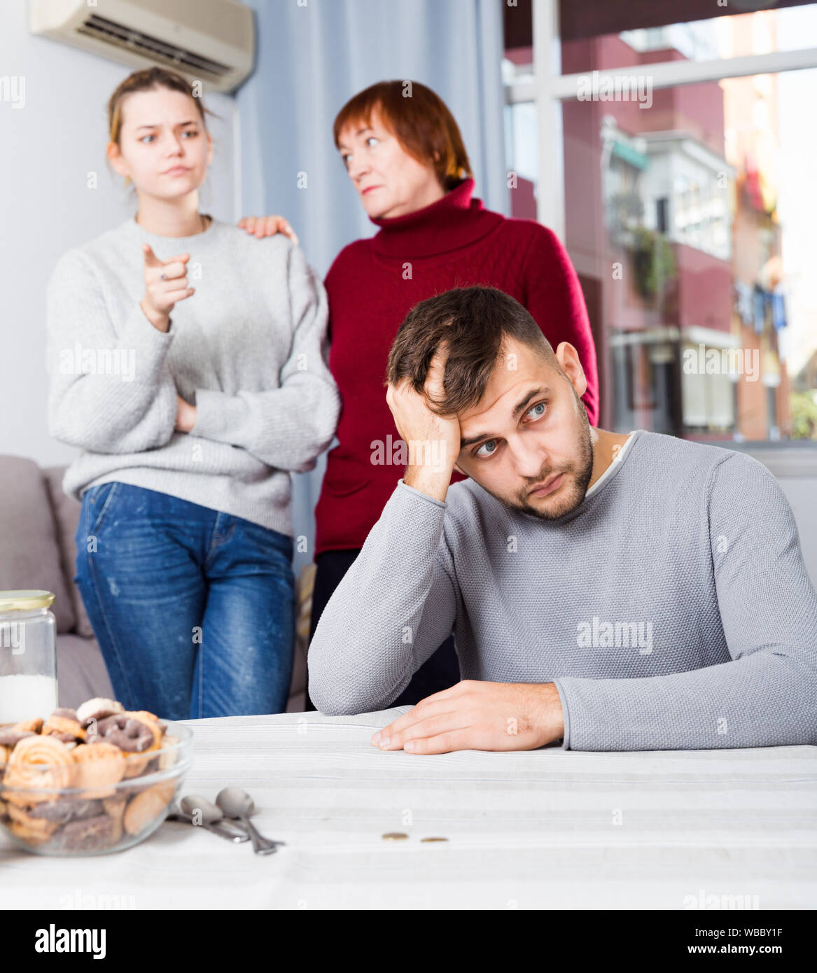 Portrait of chagrined guy sitting separately having problems in ...
