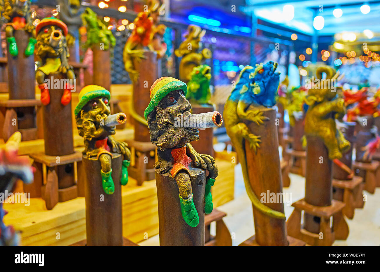 Handmade incense censers with figurines of rastaman, chameleon, elephant and other characters on the counter of souvenir stall in Chiang Mai Night Mar Stock Photo