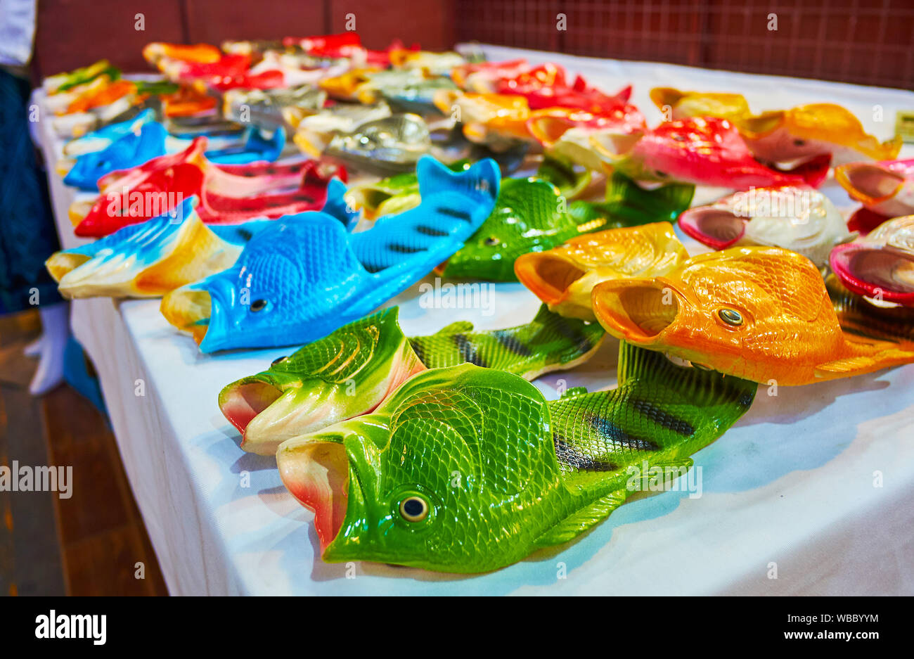 The counter of Chiang Mai Night Market stall with colorful unusual fish rubber slippers, Thailand Stock Photo