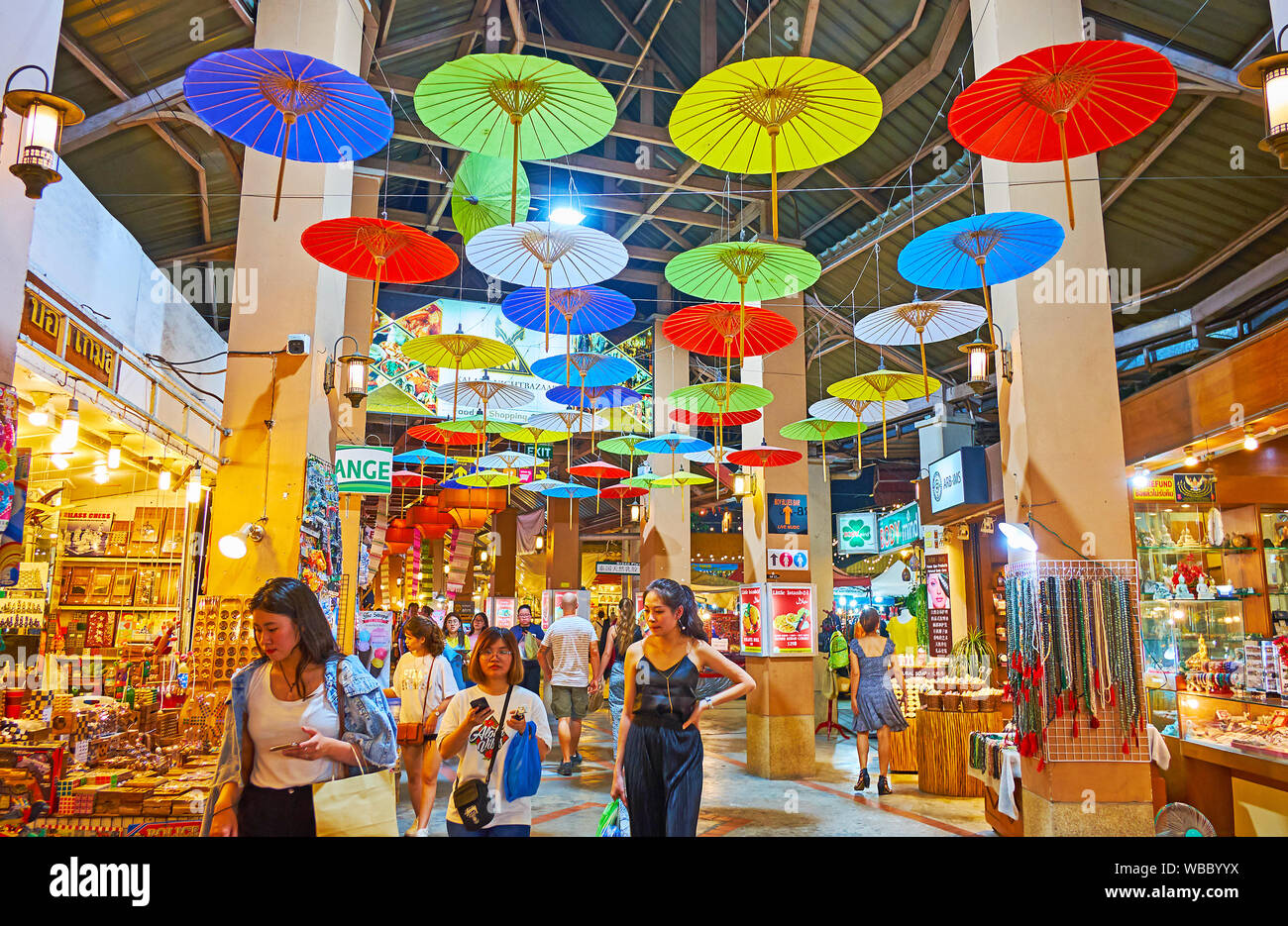 CHIANG MAI, THAILAND - MAY 2, 2019: The covered alleyway of Kalare Night Market is decorated with  colored Oriental umbrellas, hanging from the ceilin Stock Photo