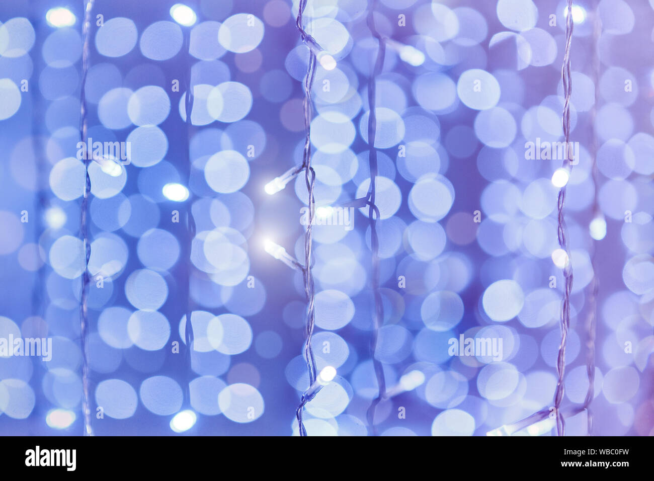 Soft colorful bokeh background. Luminous garlands of electric lights. Copy space to add text. Saturated colors. Blurry abstraction. Gentle tone. Stock Photo