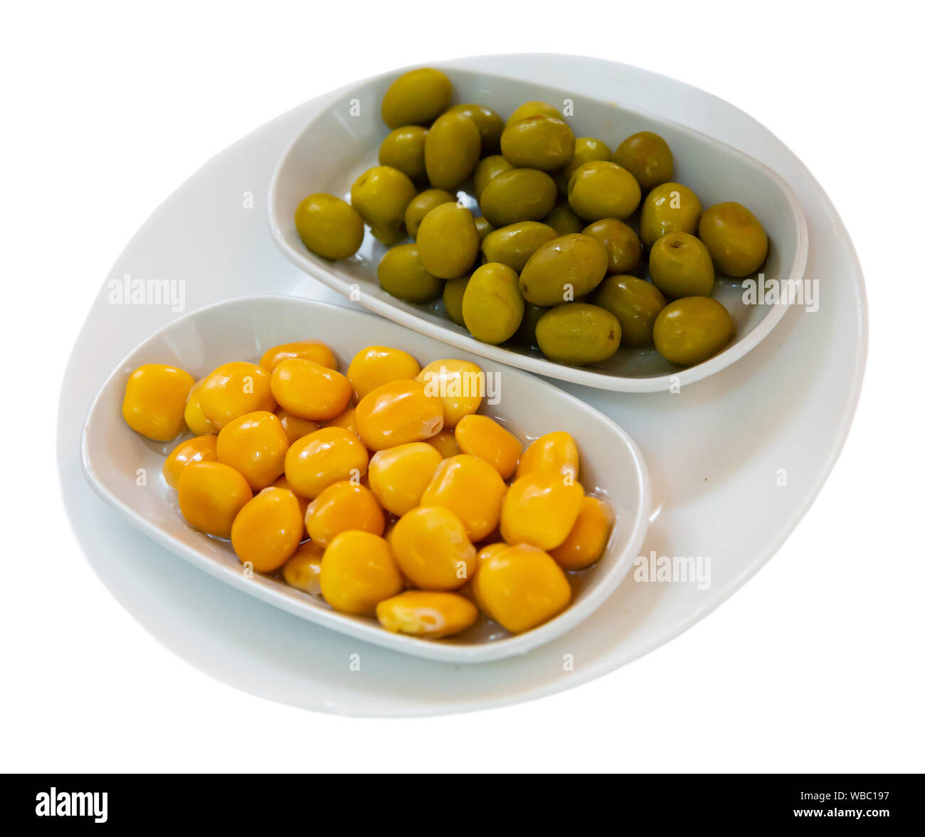 Delicious spanish tapas  from olives and pickled beans at plate. Isolated over white background Stock Photo