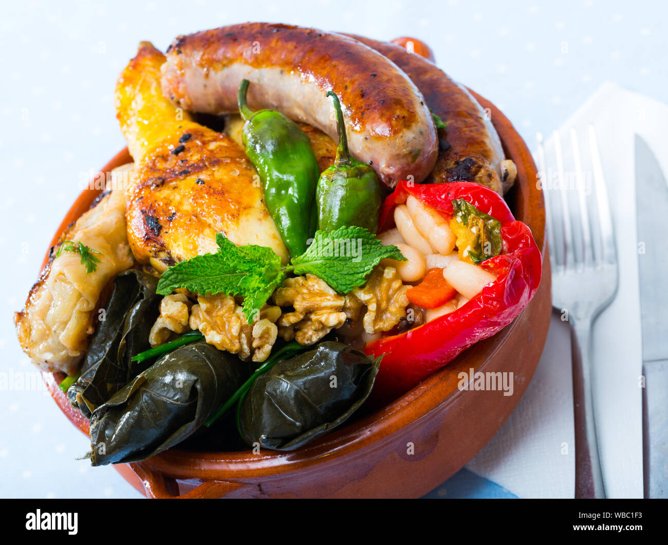 Bulgarian dish kapama with grilled sausage, grape rolls, stuffed pepper ...