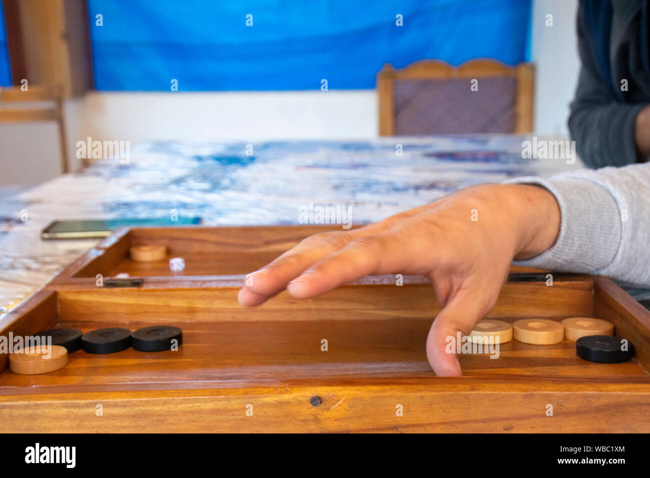 Playing backgammon on a wooden table with dices. Stock Photo