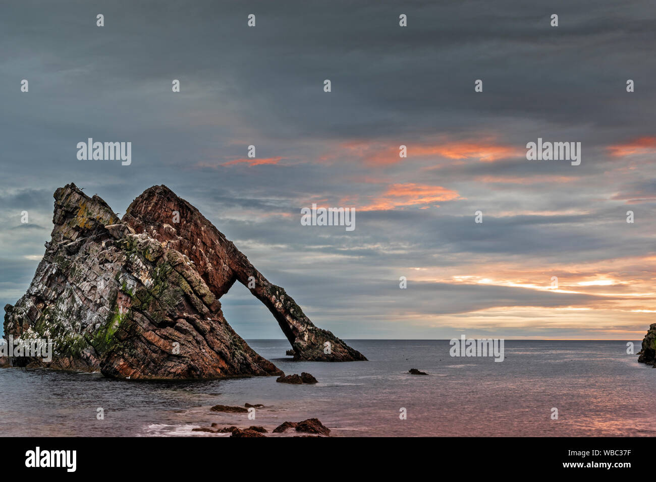 BOW FIDDLE ROCK PORTKNOCKIE MORAY SCOTLAND GREY CLOUD SUNRISE WITH PINK LIGHTS SUMMER MIDAUGUST Stock Photo