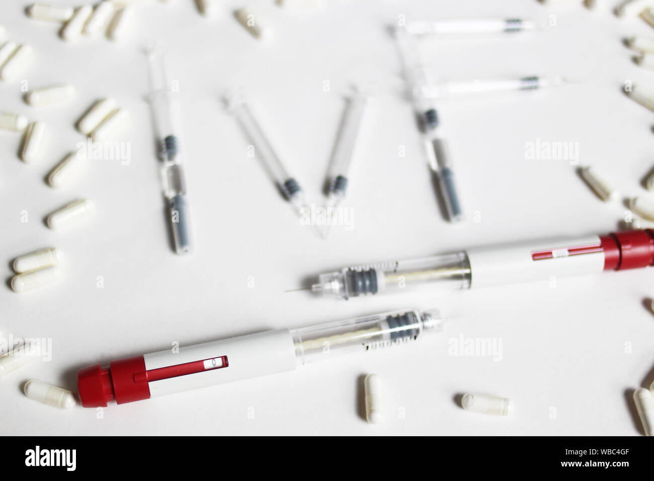 The abbreviation IVF is laid out in wooden letters on a blue background. In  vitro injection pen, tablet and ampoule. A syringe with a thin huge. IVF c  Stock Photo - Alamy