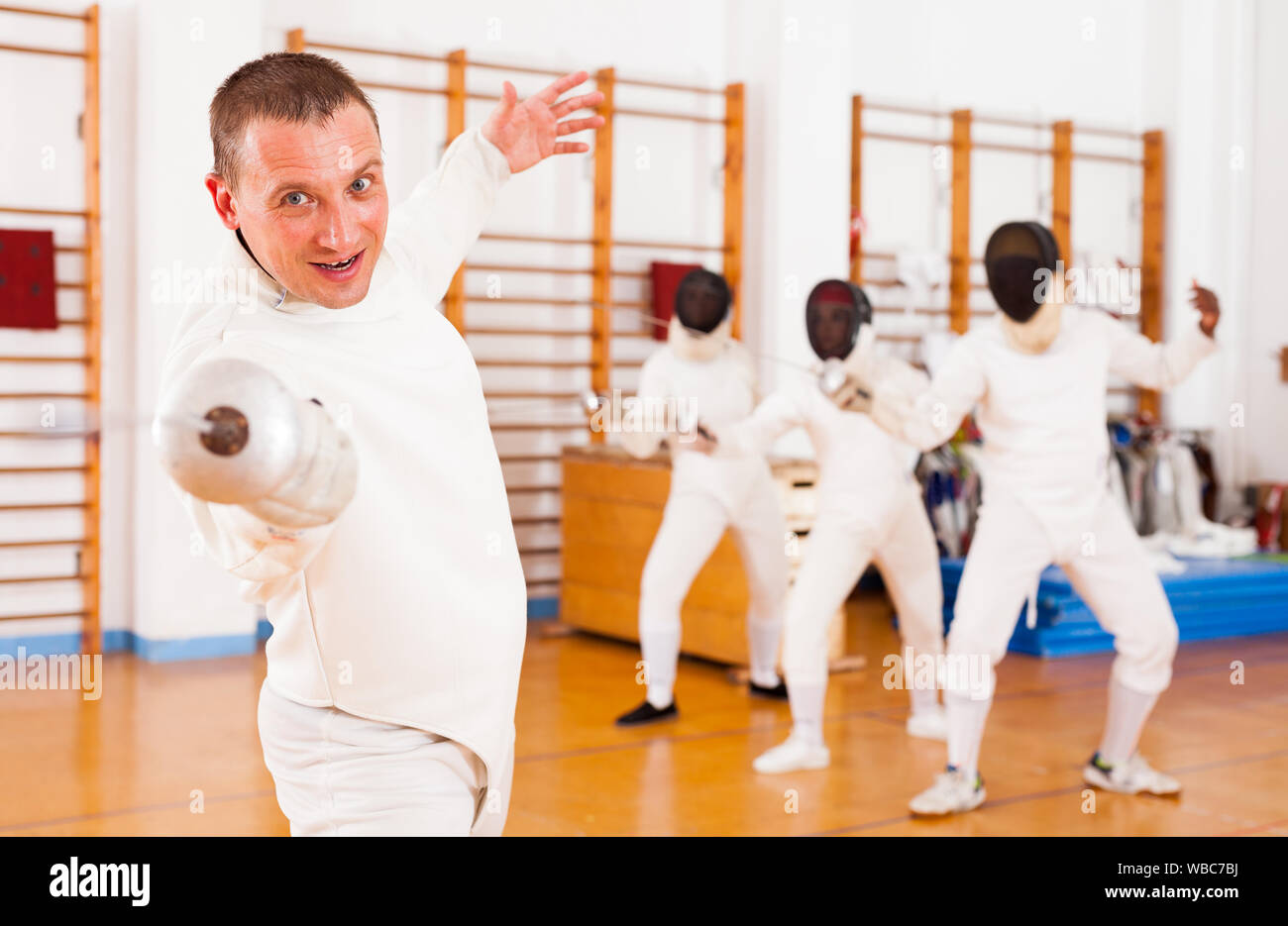 Fencing Training Roon Sporty young man fencer practicing effective fencing techniques in ...