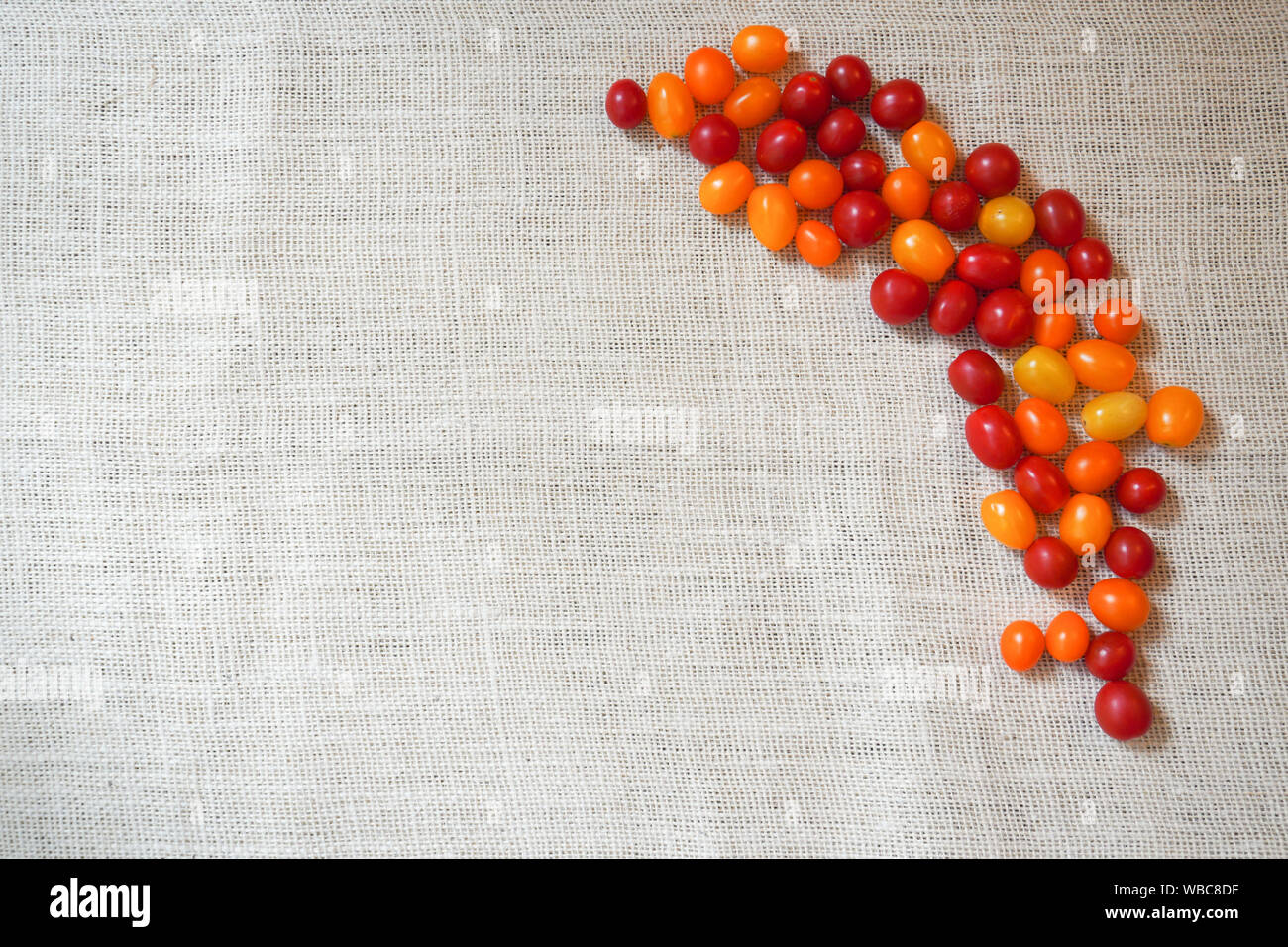 A variety of colors of cherry tomatoes on burlap Stock Photo