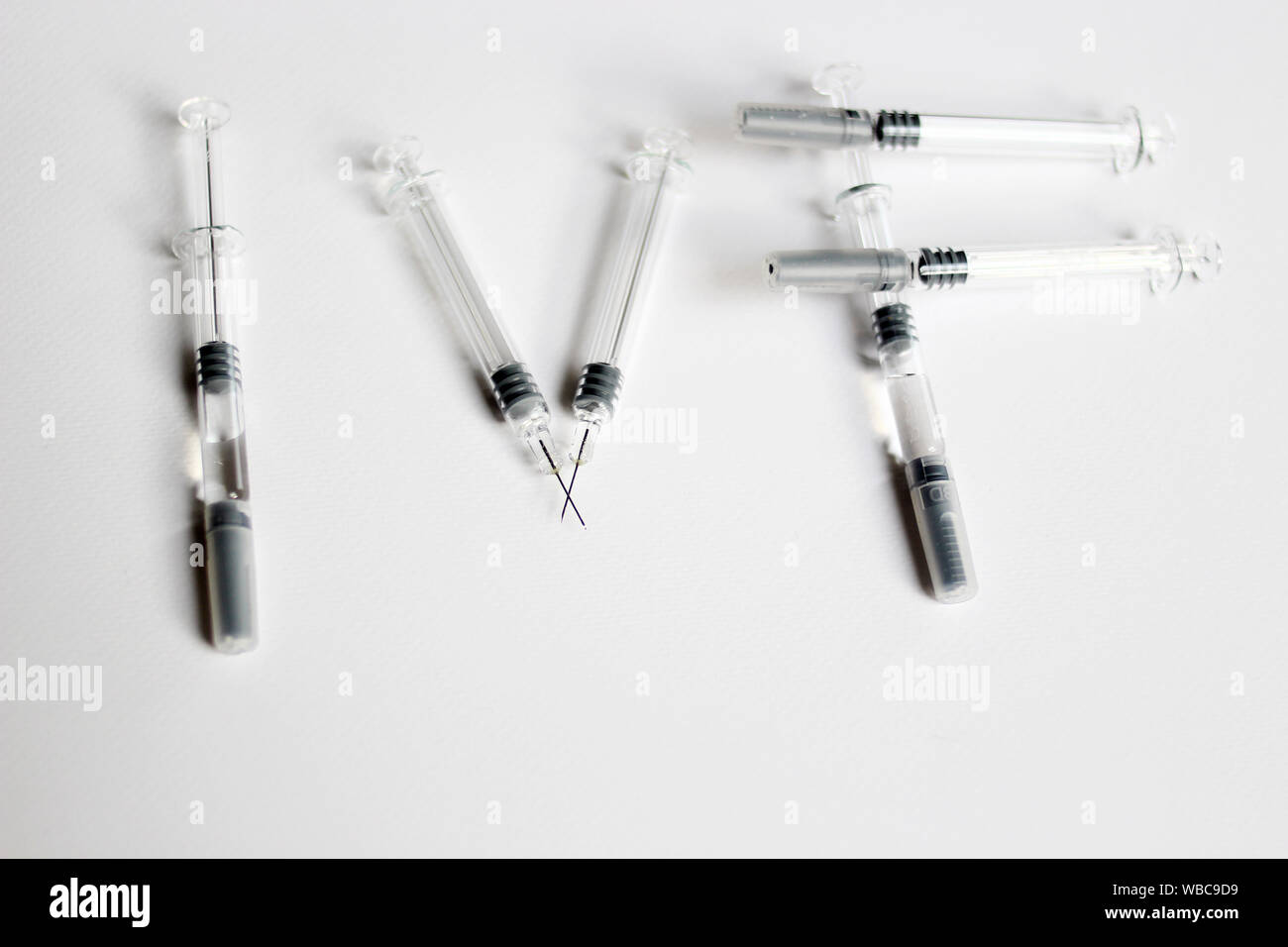 In Vitro Fertilization injection pen. IVF treatment drugs, syringes, needles and pills.  IVF spelled with syringes Stock Photo