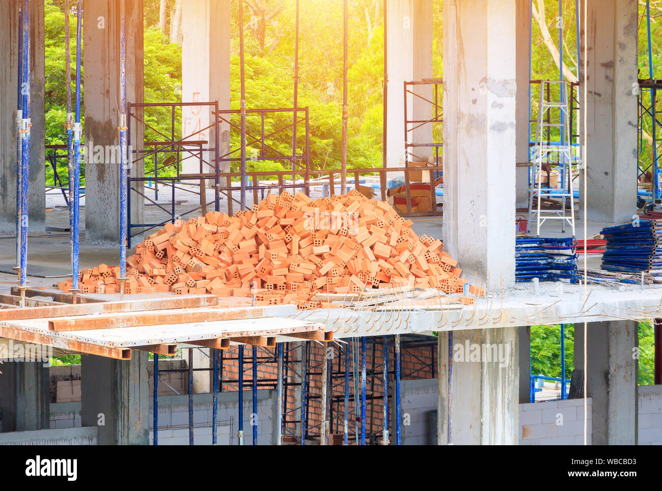 Red bricks pile interior room building construction and cement wall background Stock Photo