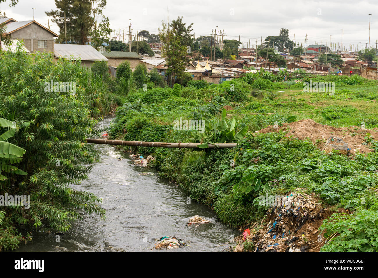 Mathare river with rubbish in it running past housing, Nairobi, Kenya Stock Photo