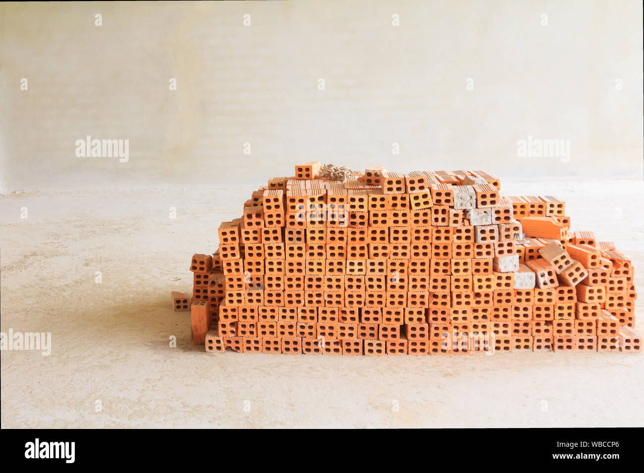 Red bricks pile interior room building construction and cement wall background Stock Photo