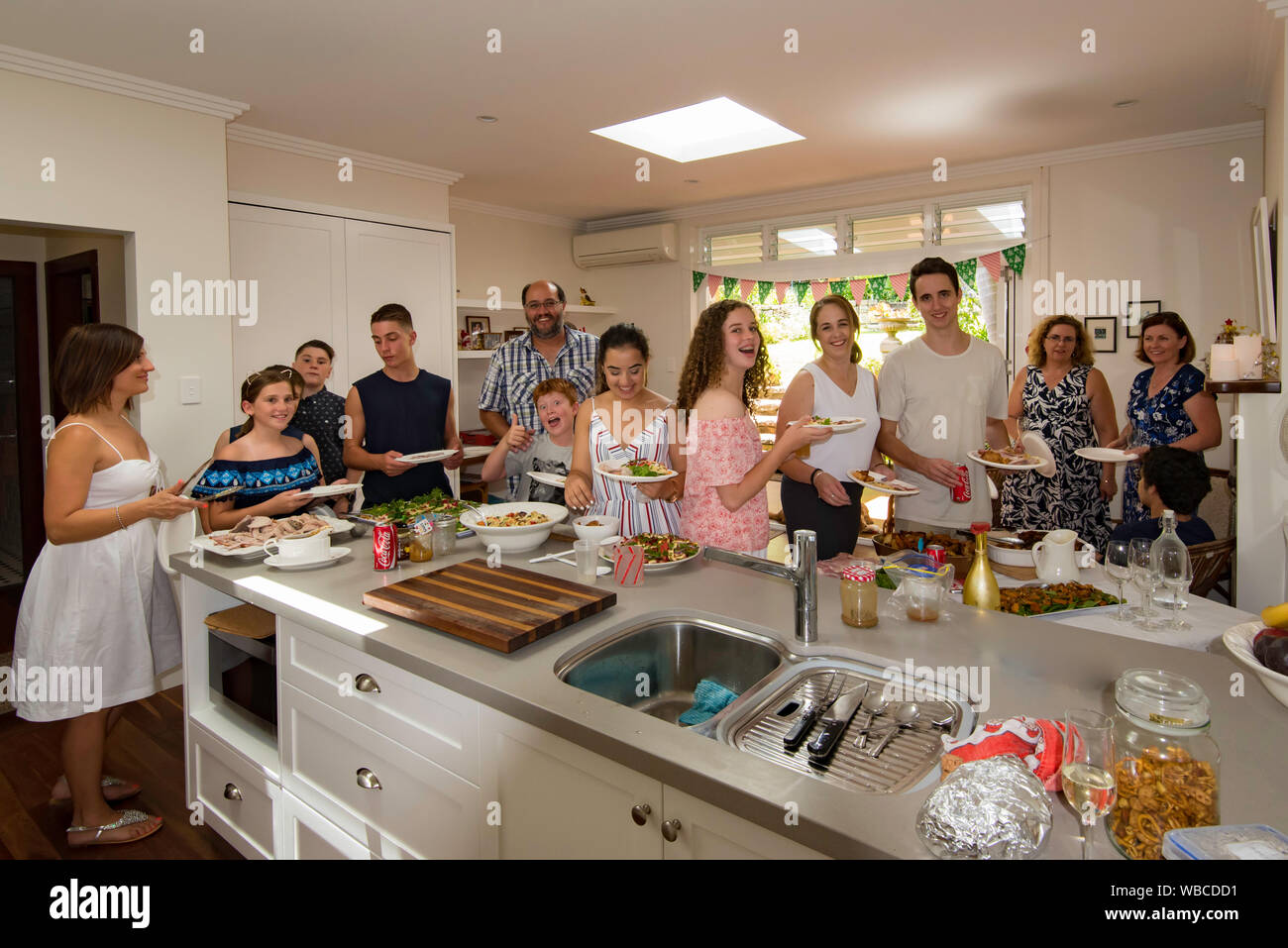 Christmas in Australia, an extended family serves themselves a traditional Australian Christmas lunch of hot meats and vegetables and cold salads Stock Photo