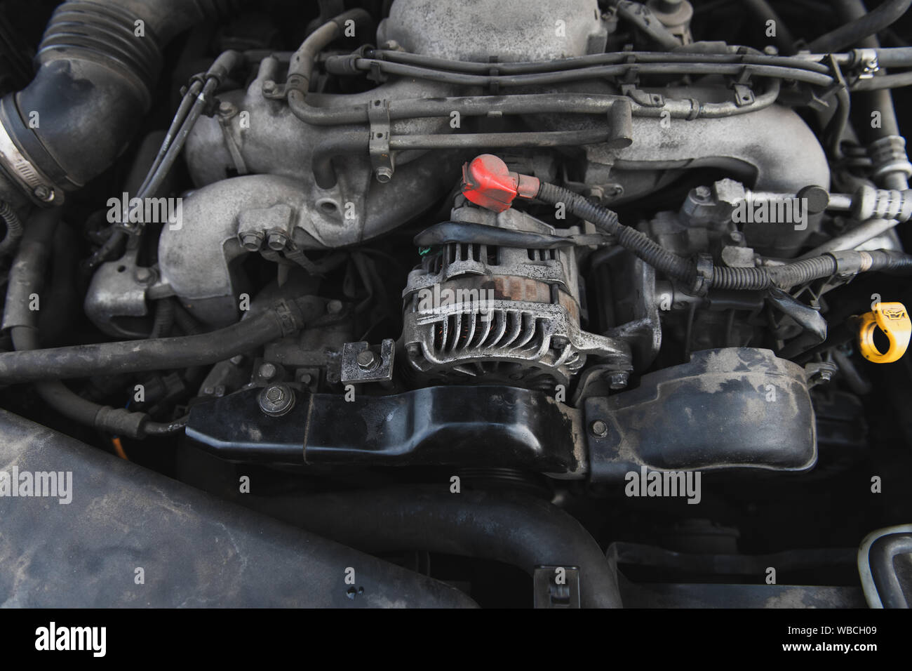 Dusty boxer engine under the hood. Generator and other parts of the motor Stock Photo Alamy
