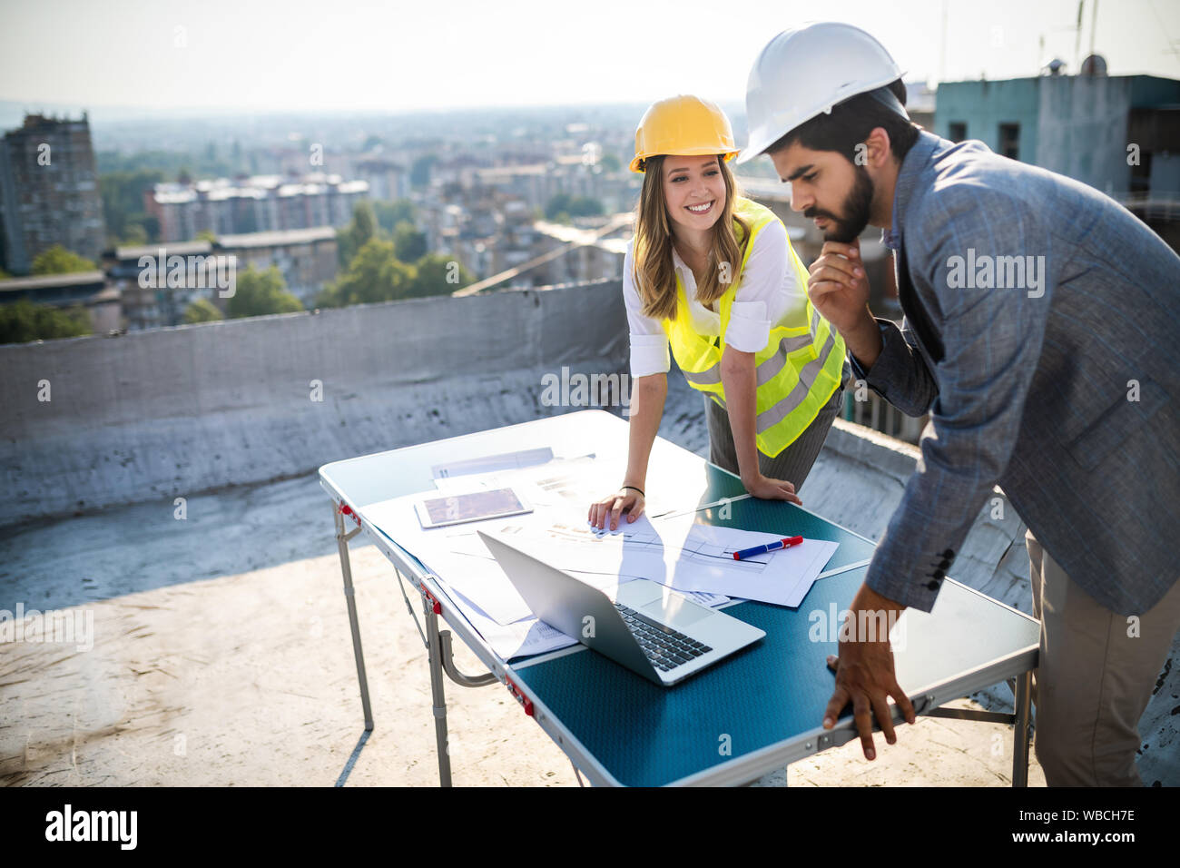 Architects team and engineers looking paper plans at construction site. Stock Photo