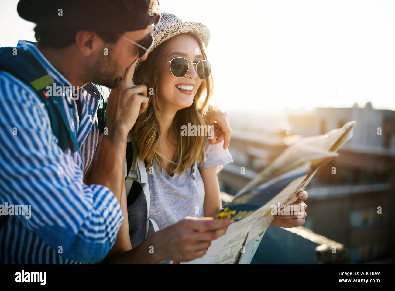 Happy young couple of travellers holding map in hands Stock Photo