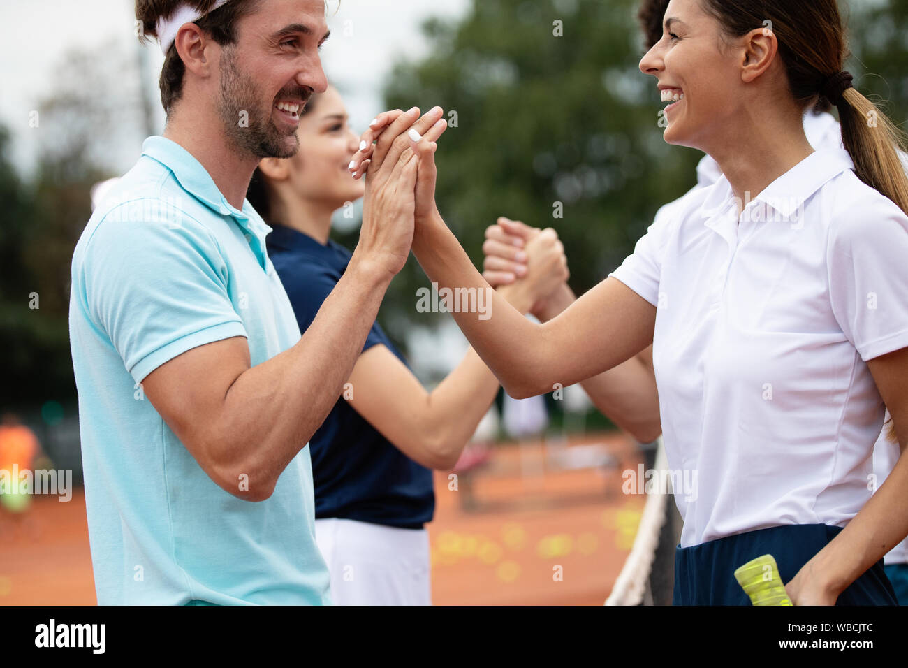 Group of healthy happy friends at the club playing tennis Stock Photo