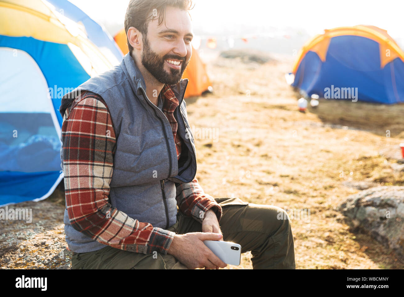 Handsome cheerful bearded man camping outdoors Stock Photo