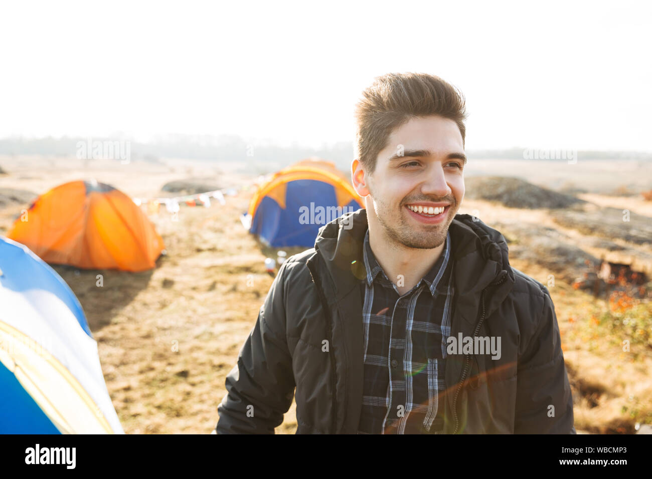 Handsome cheerful man camping outdoors Stock Photo